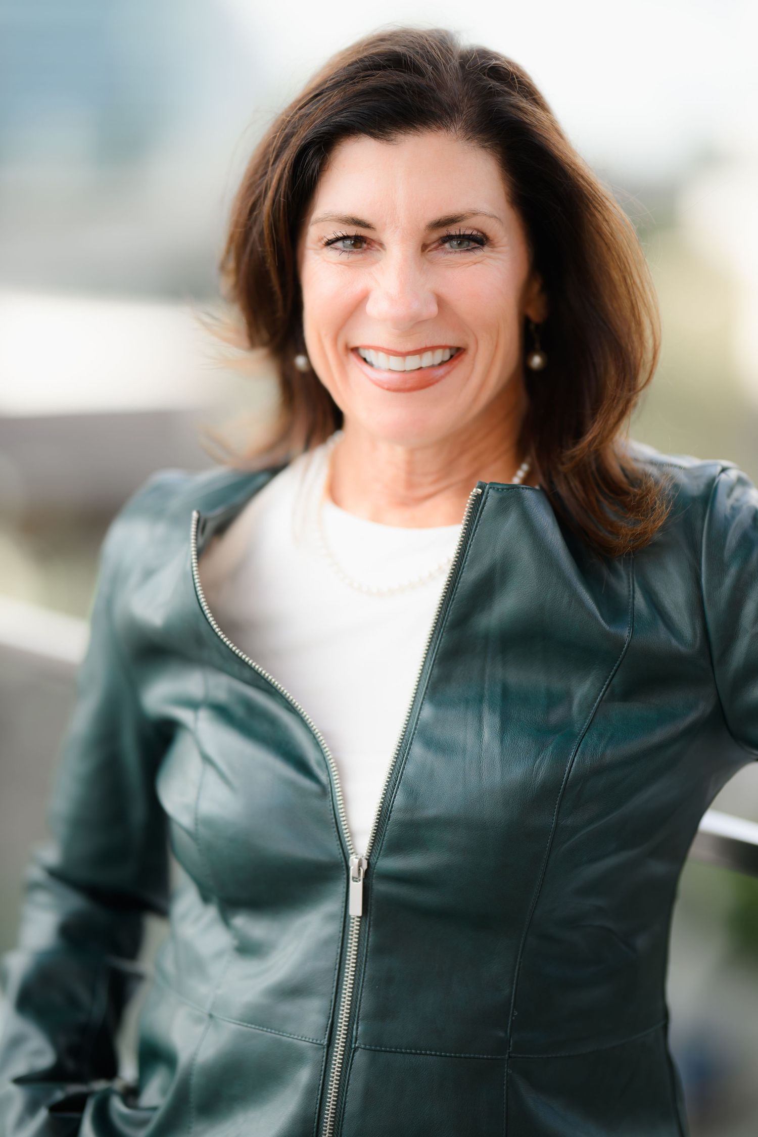 Holly, a LCSW in San Diego posing in a green jacket for her headshot and  branding session at the UTC mall.