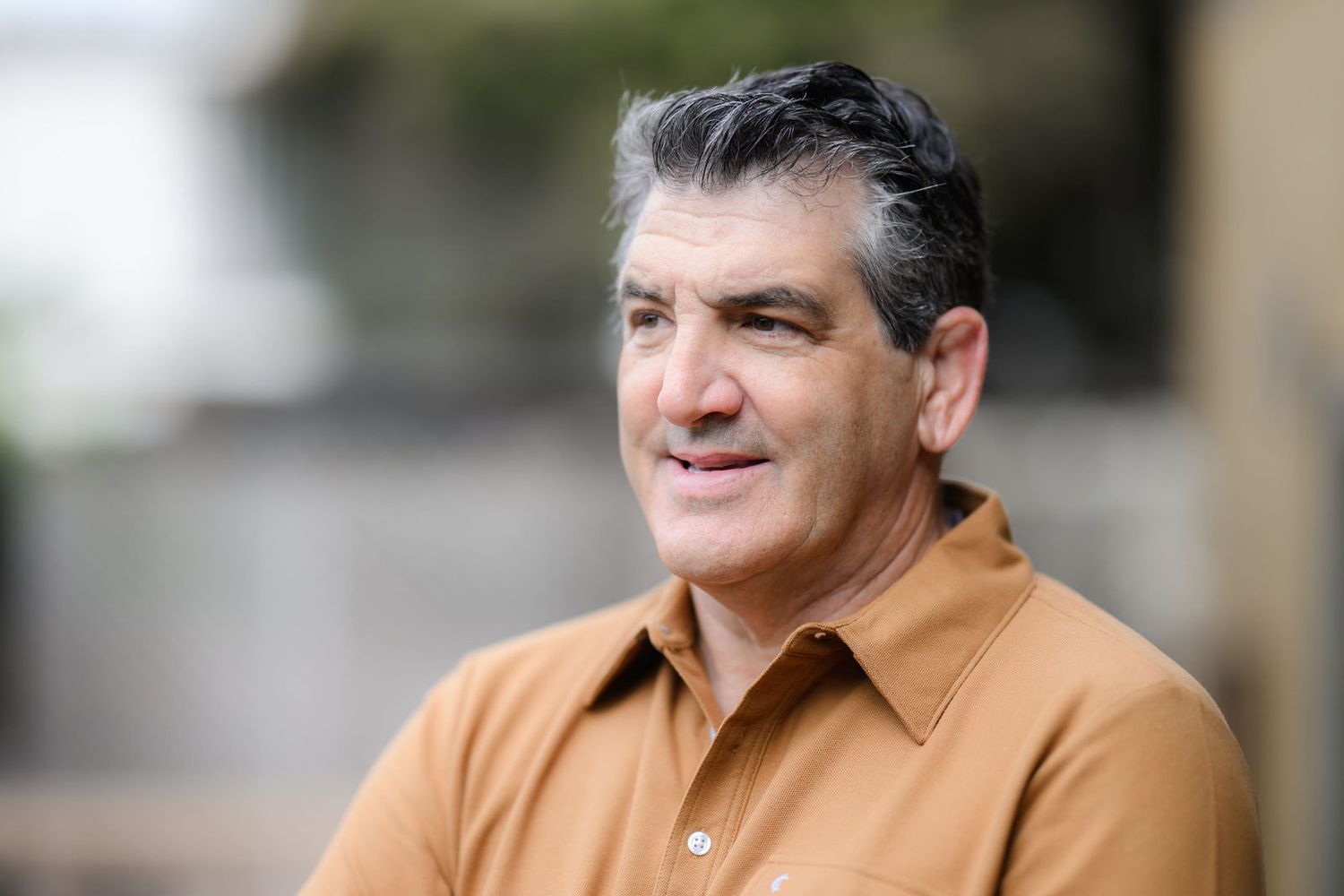 Bill having a headshot and personal branding photo session in his back yard wearing a gold shirt in La Jolla in San Diego.