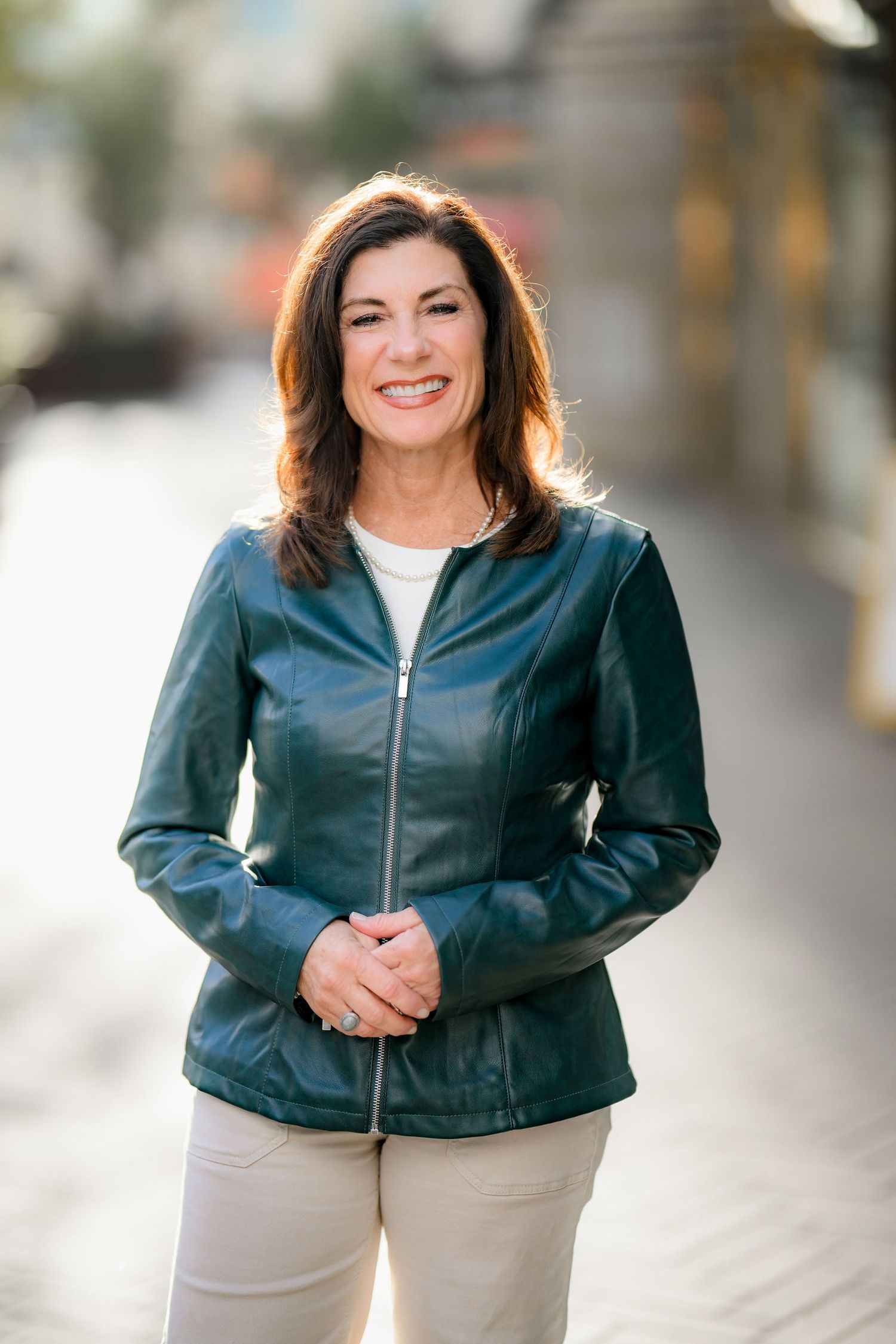 Holly posing in the mall in a green jacket stating she loving feeling like a model for a day during her headshot and personal branding