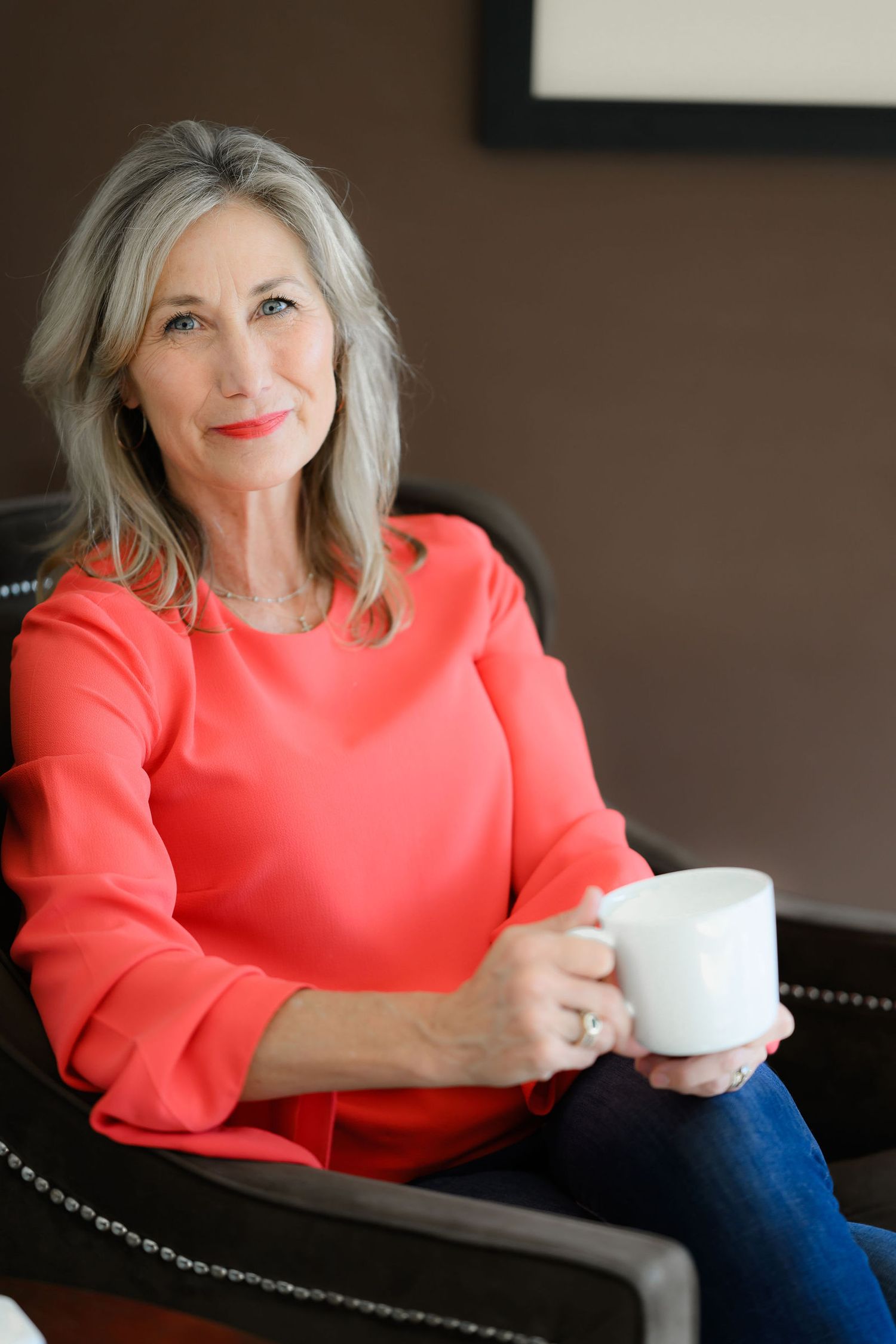 India a certified divorce coach wearing a nice red top posing for her personal branding and headshot photoshoot in San Diego at her home.