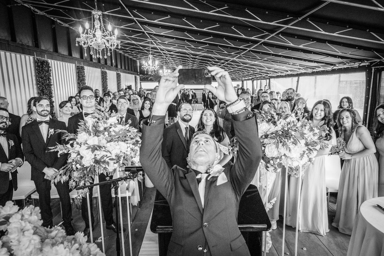 Wedding officiant takes selfie with the married couple and all their guests