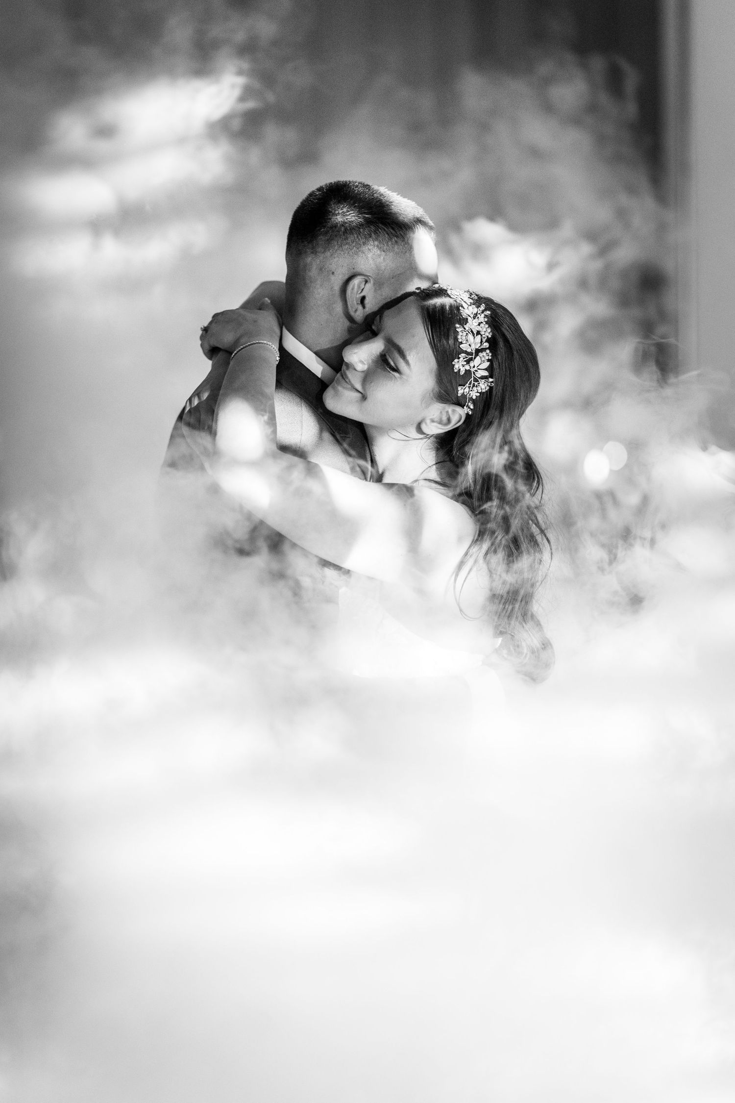 Bride and groom surrounded by fog during their first dance