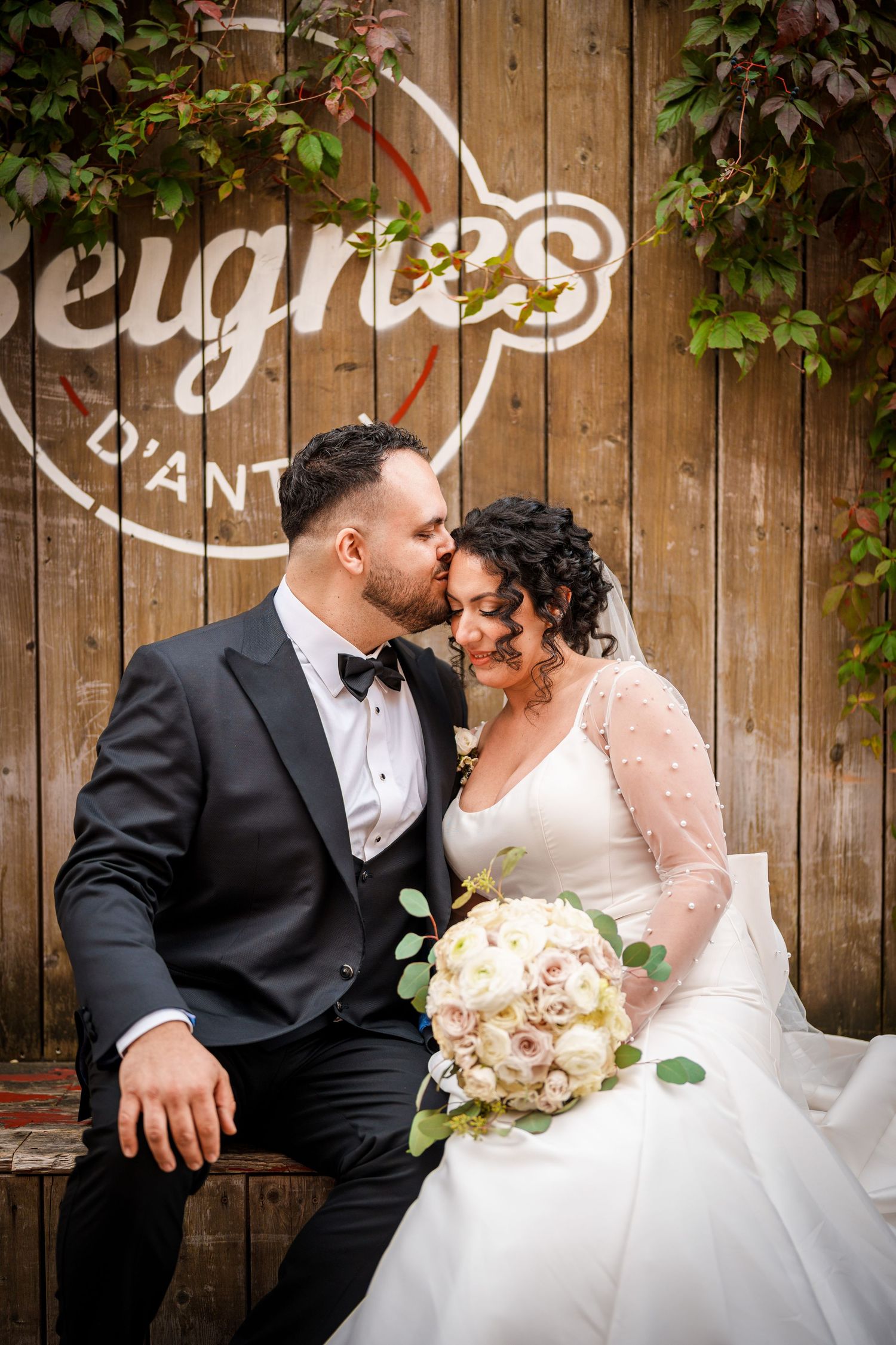 Bride and groom sharing a kiss on a bench in Montreal