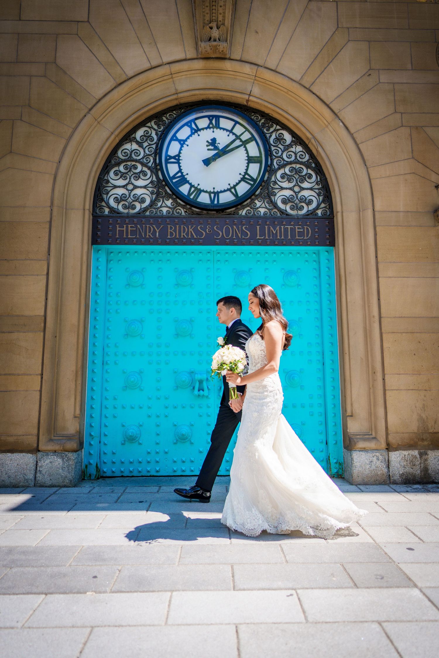 Bride and groom walking by Birks in Montreal