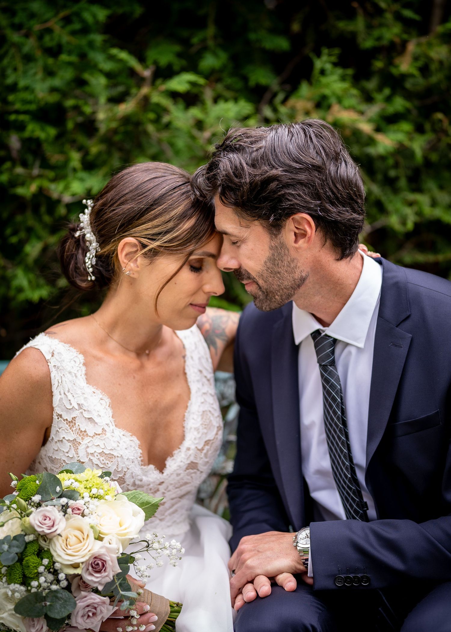 Emotional married couple hugging behind foliage in Laval, Quebec