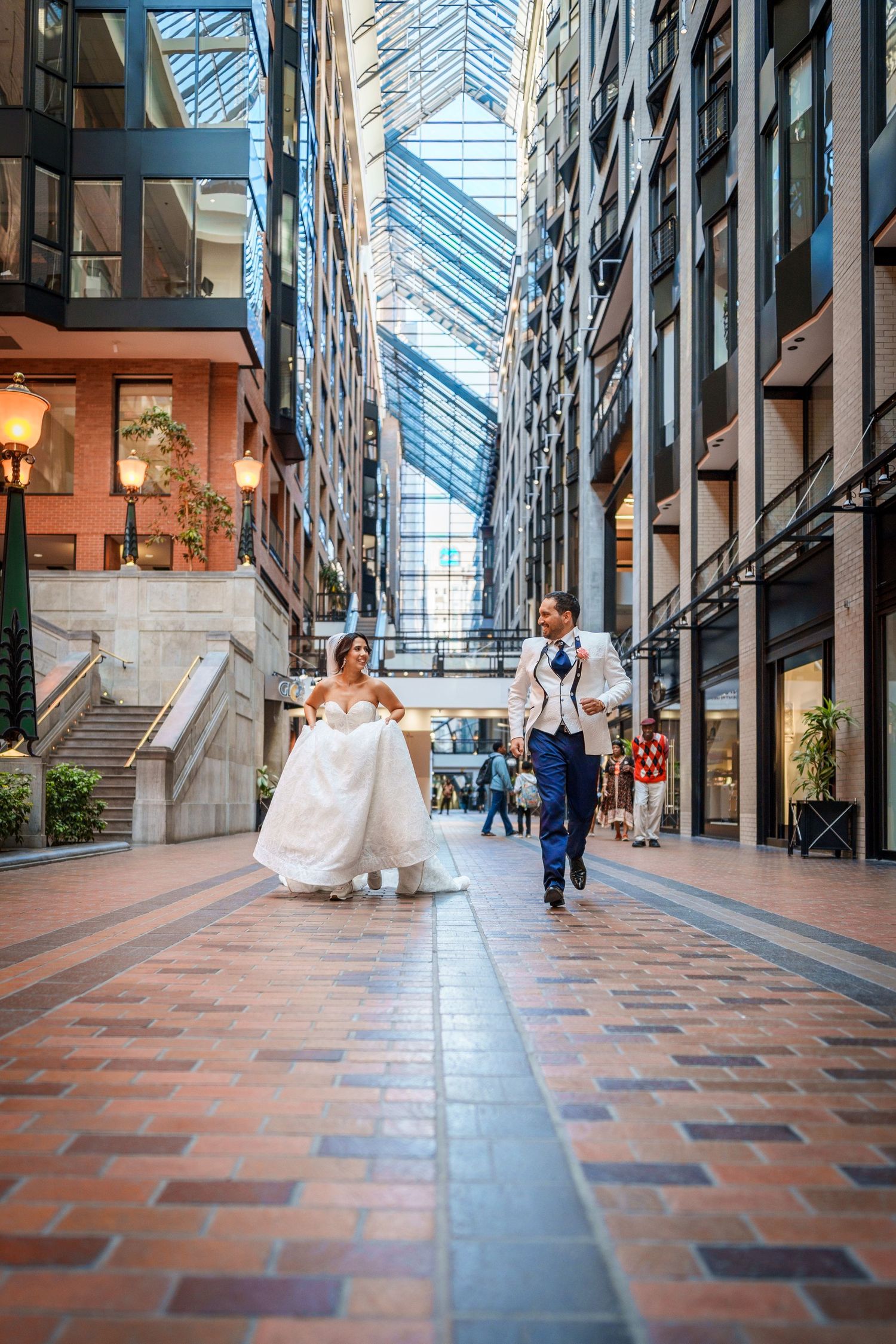 Bride and groom running through the World Trade Centre in Montreal