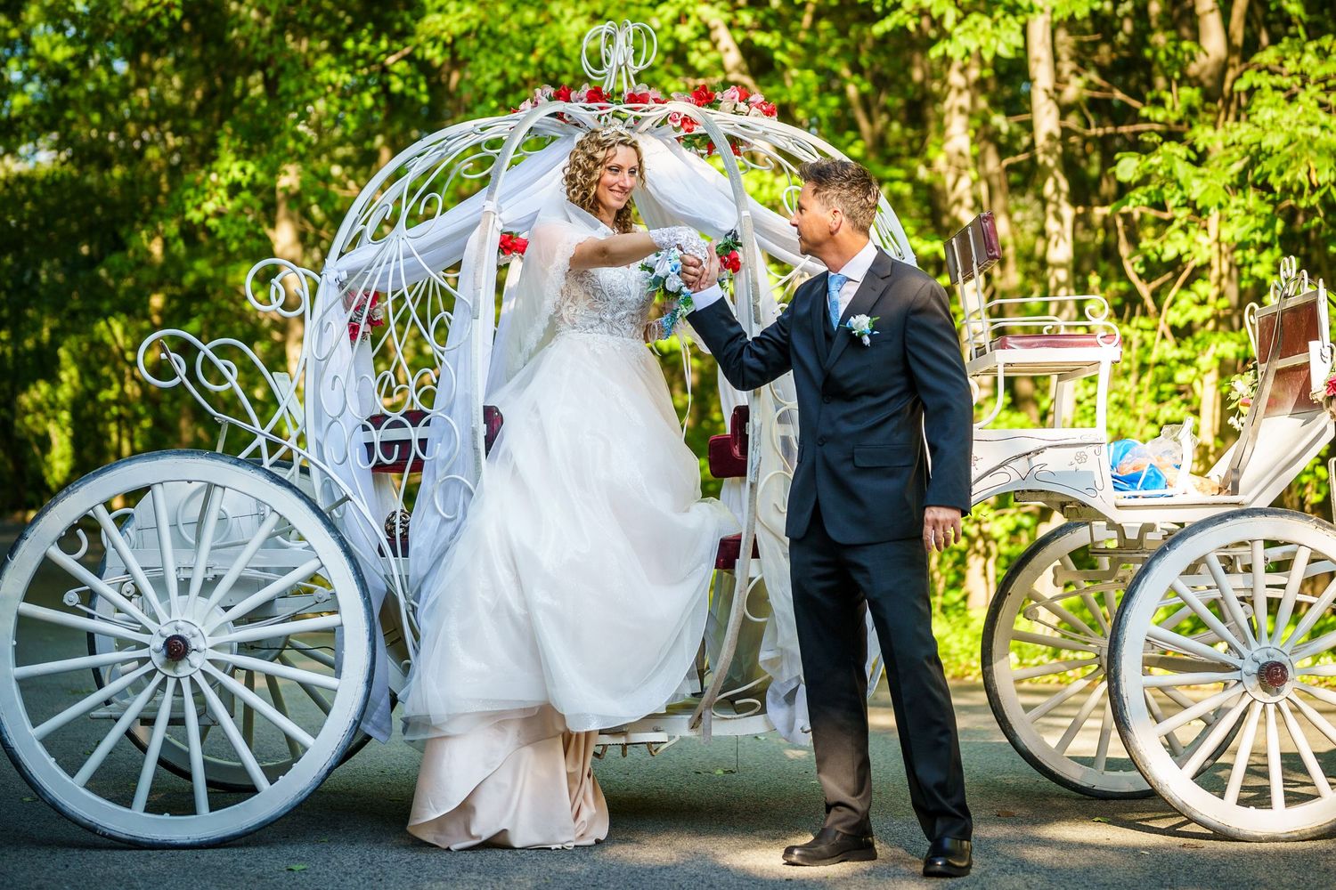 Groom helps his bride exit her horse-drawn carriage