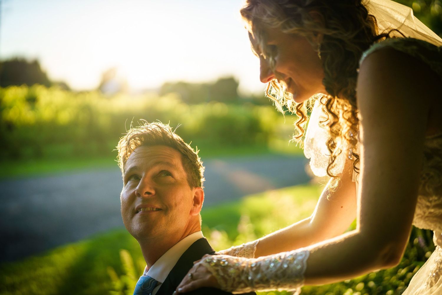 Bride behind her groom with the sun setting in a grape orchard in Laval, Quebec