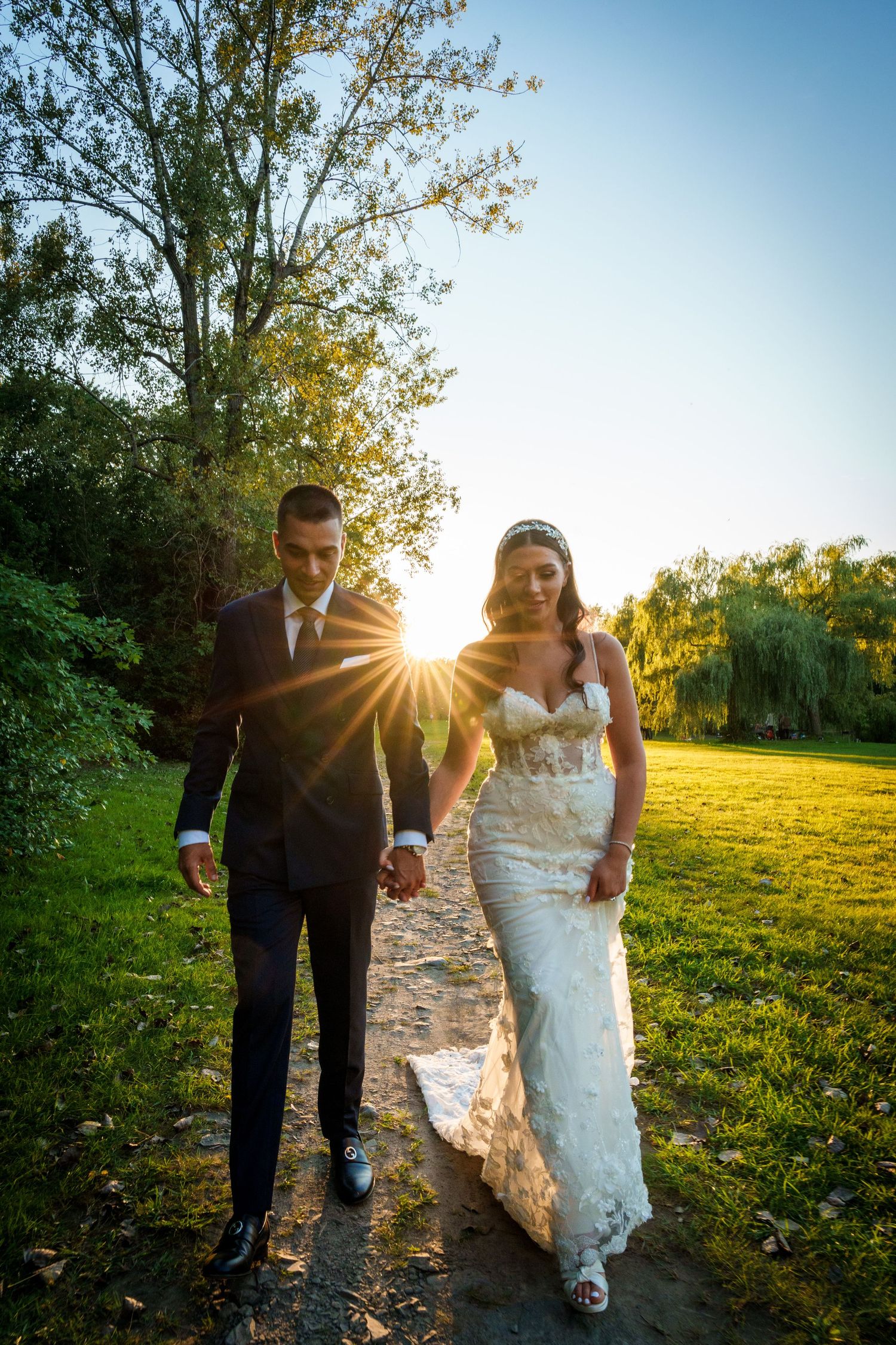 Bride and groom walk through a park near Beaver Lake in Montreal