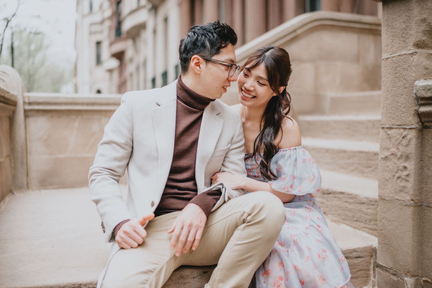 A couple sharing an intimate moment on stone steps outdoors.