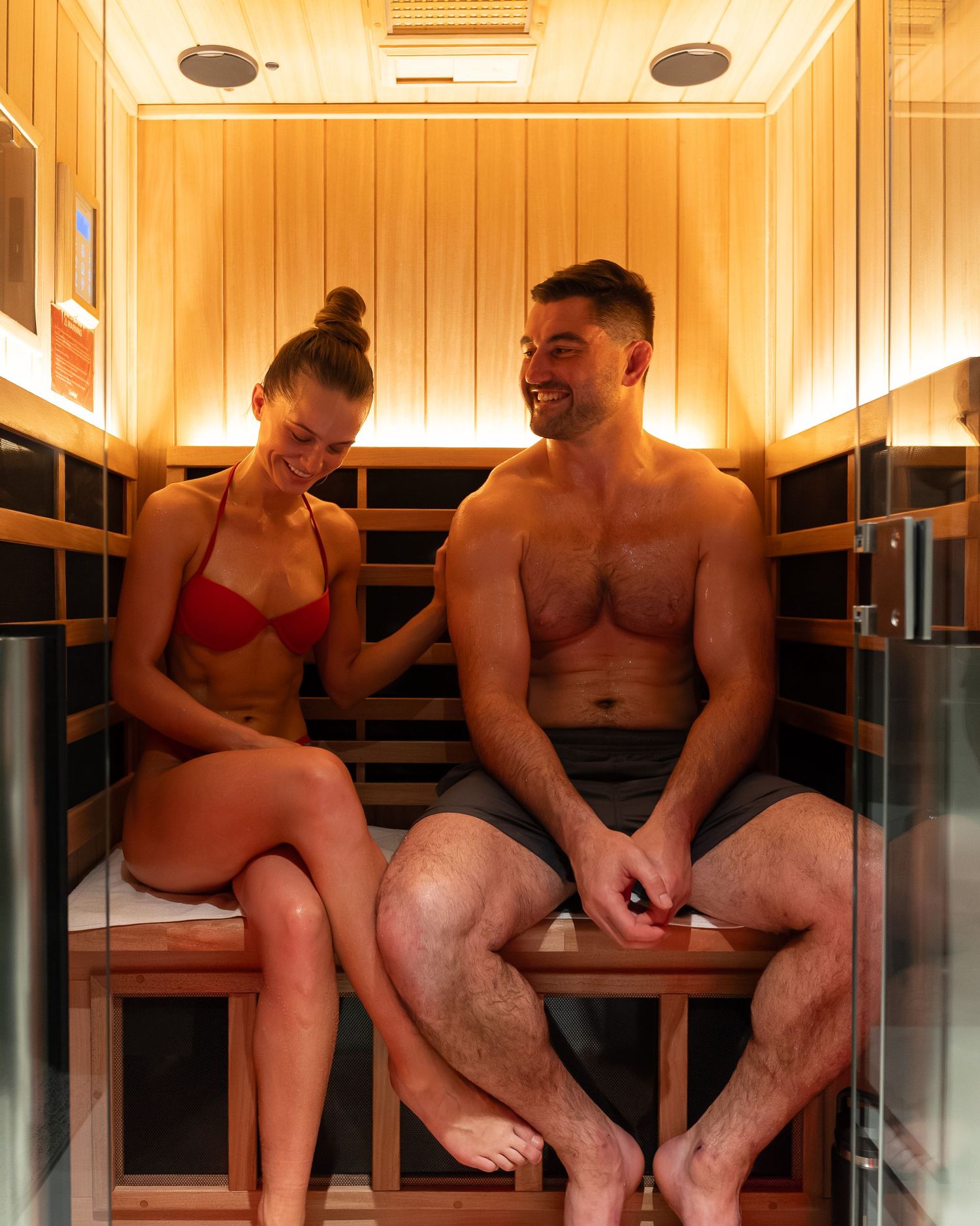Warm-lit wooden sauna interior with benches and modern lighting design.