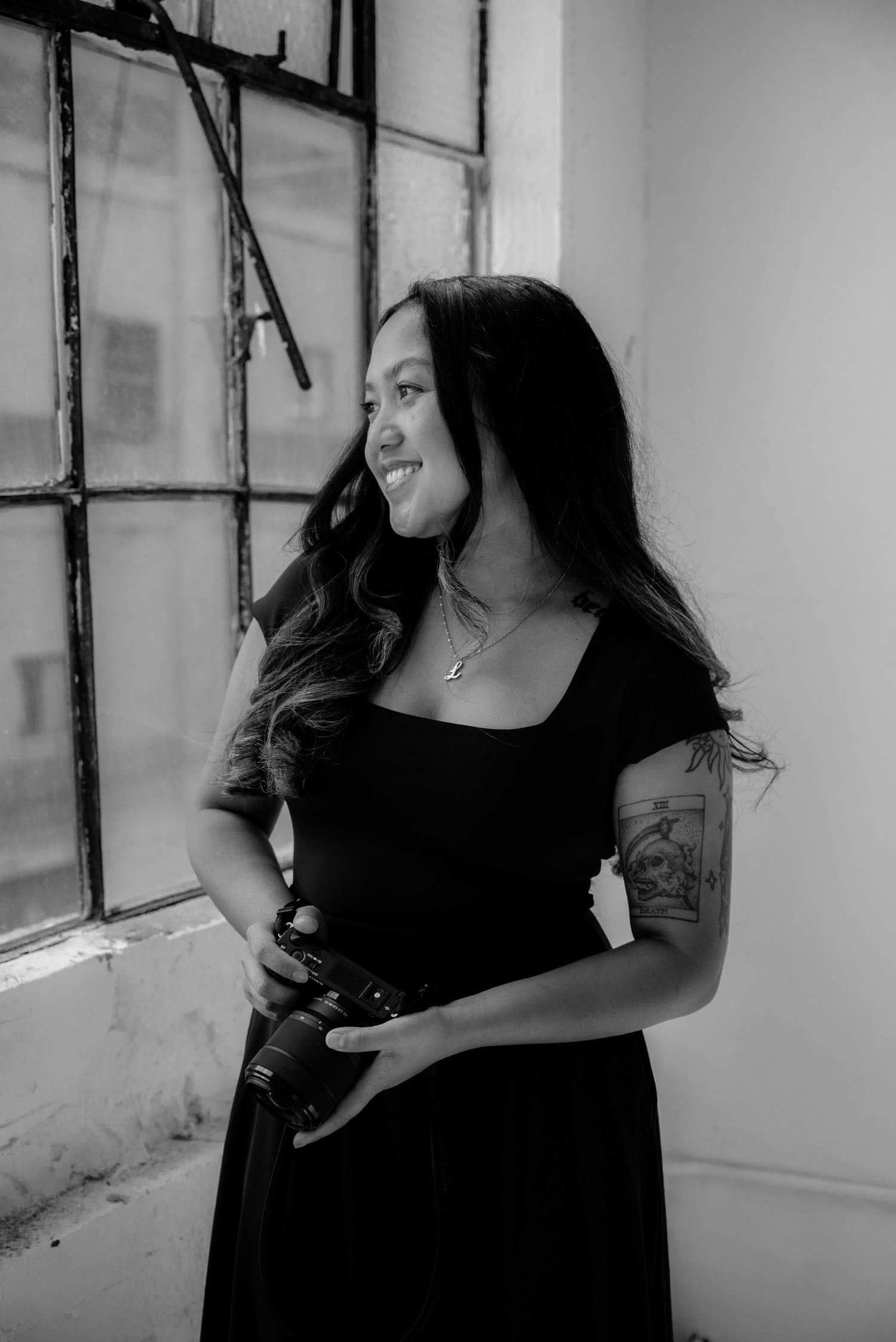 A series of black and white portraits showing a person in a black top posing against a light colored wall.