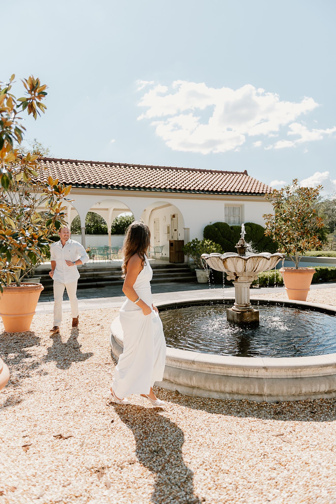 A beautiful fountain courtyard with gravel path and Mediterranean architecture creates an elegant setting.