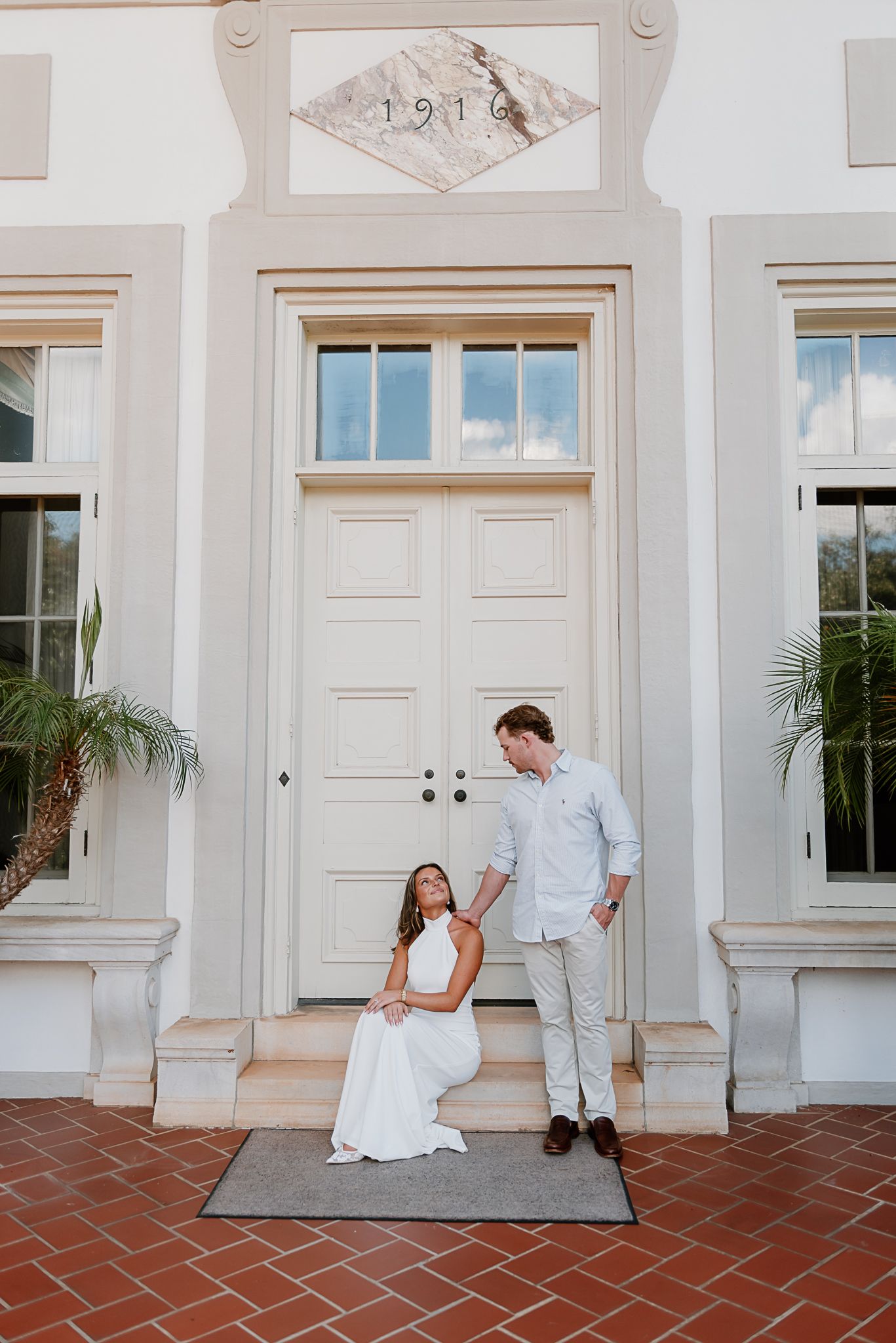 Playful wedding photo sequence on a white building's terrace with red tile flooring.