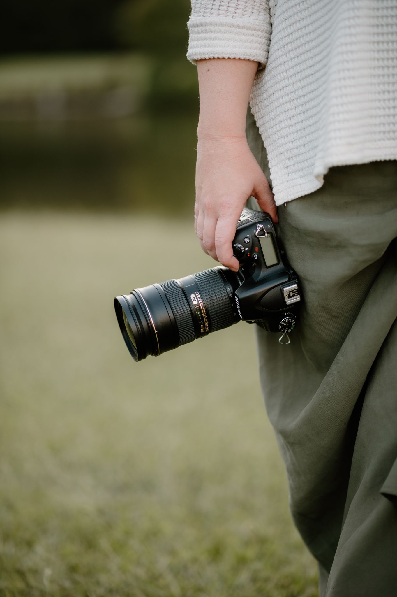 Close-up shots of a professional camera with telephoto lens being held.