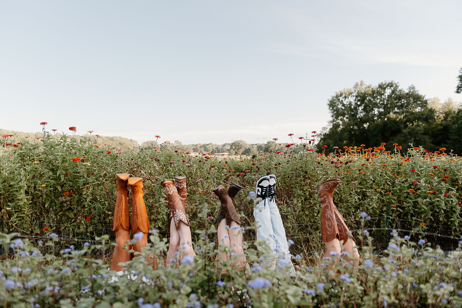Group enjoying a summer day in a wildflower field with colorful dresses.