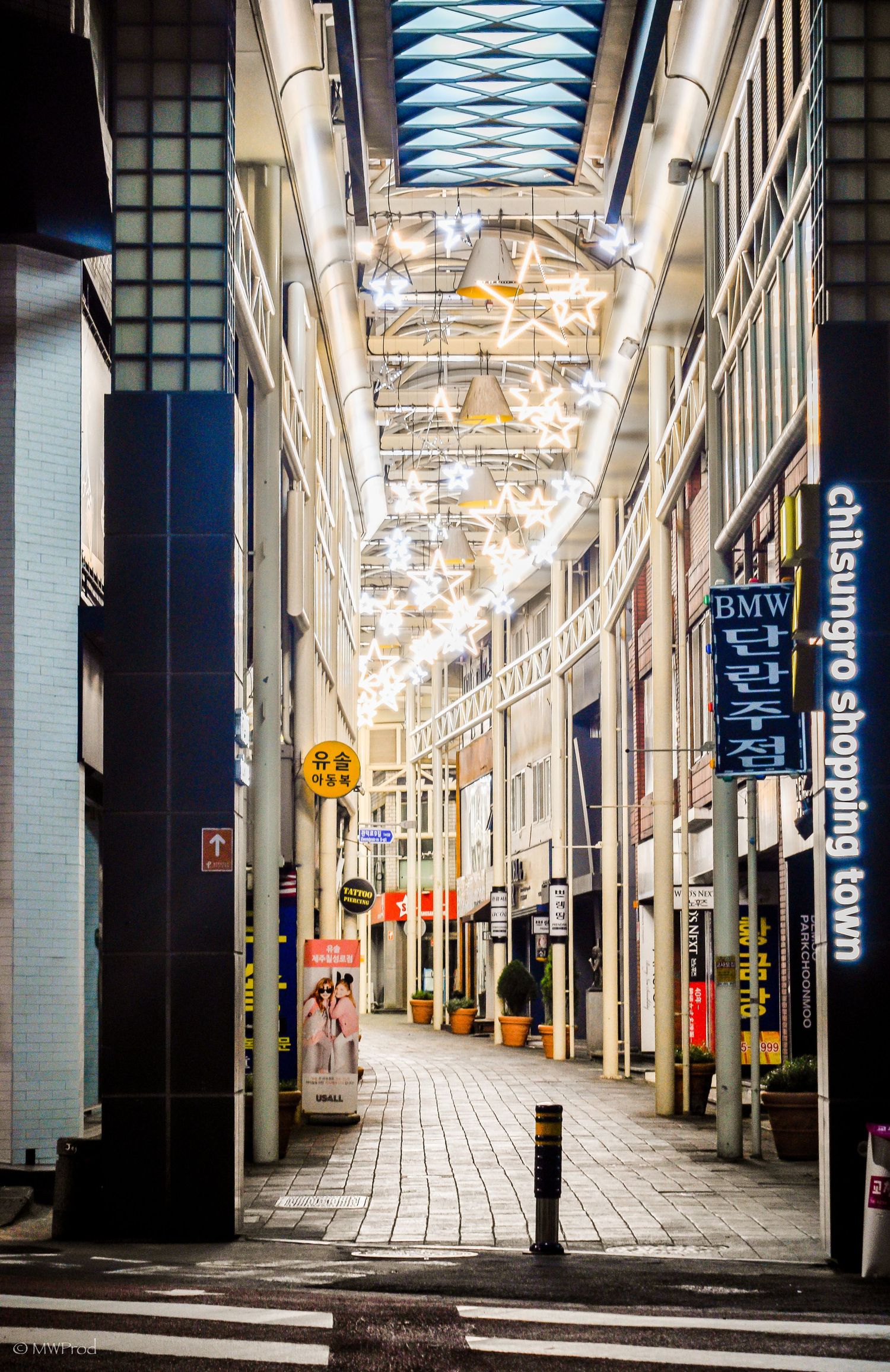 Modern shopping arcade with illuminated ceiling and tiled floor in Korea.