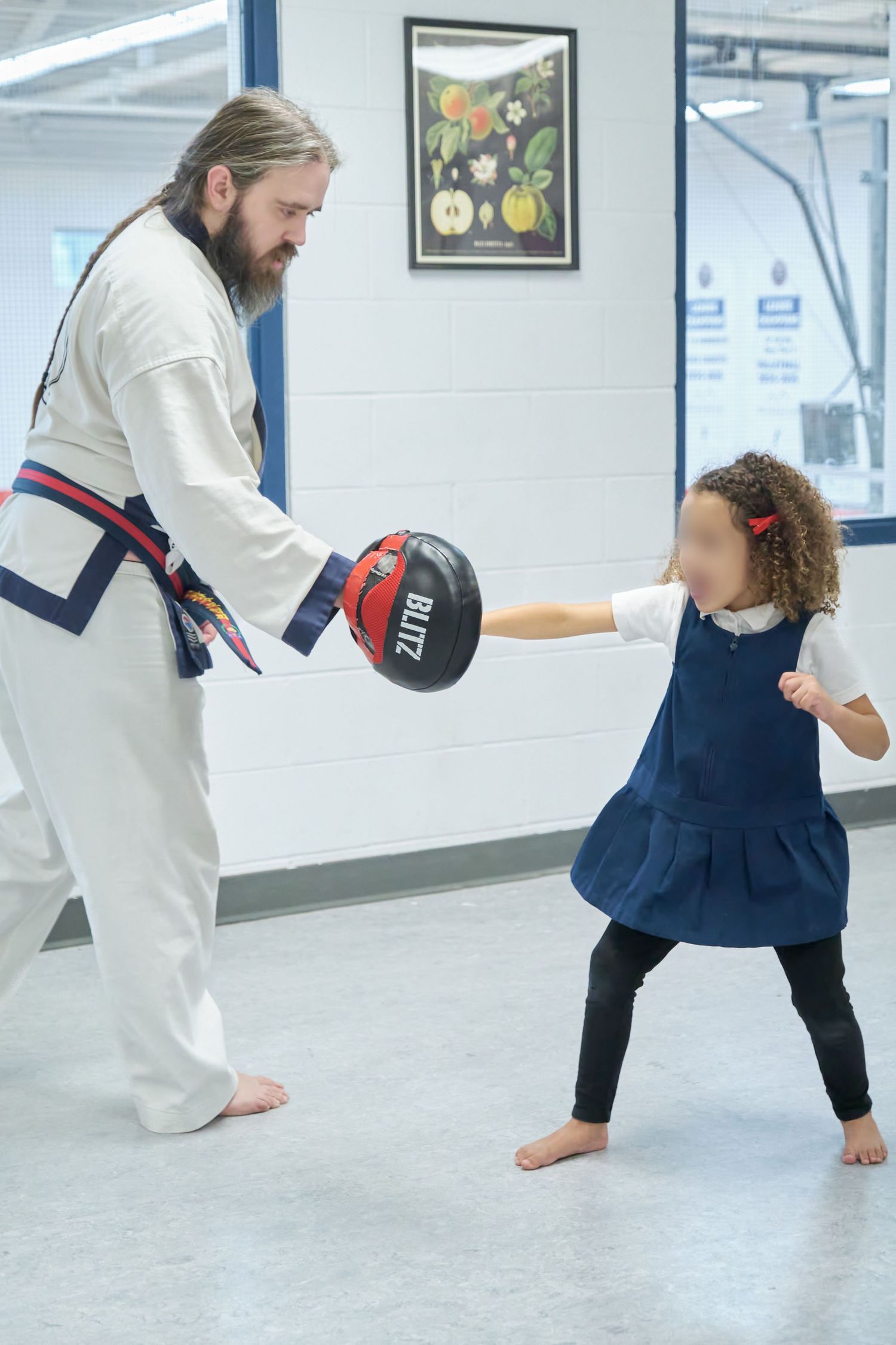 A martial arts training session shows practice moves and stances on a bright indoor studio floor.