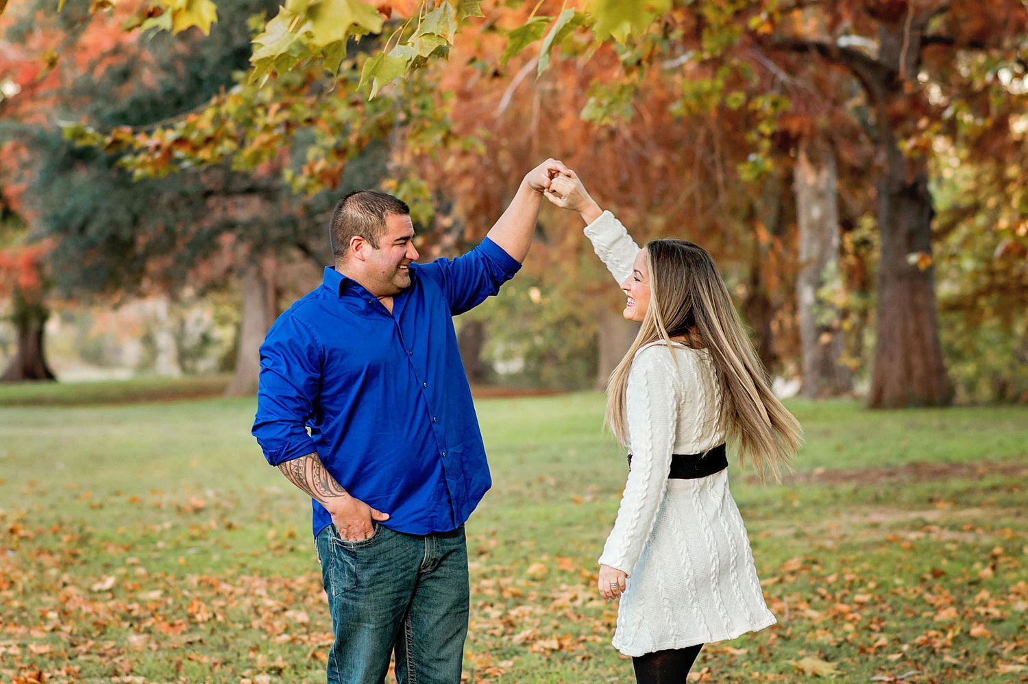 Couple enjoys romantic autumn moment surrounded by colorful fall foliage in outdoor park setting.