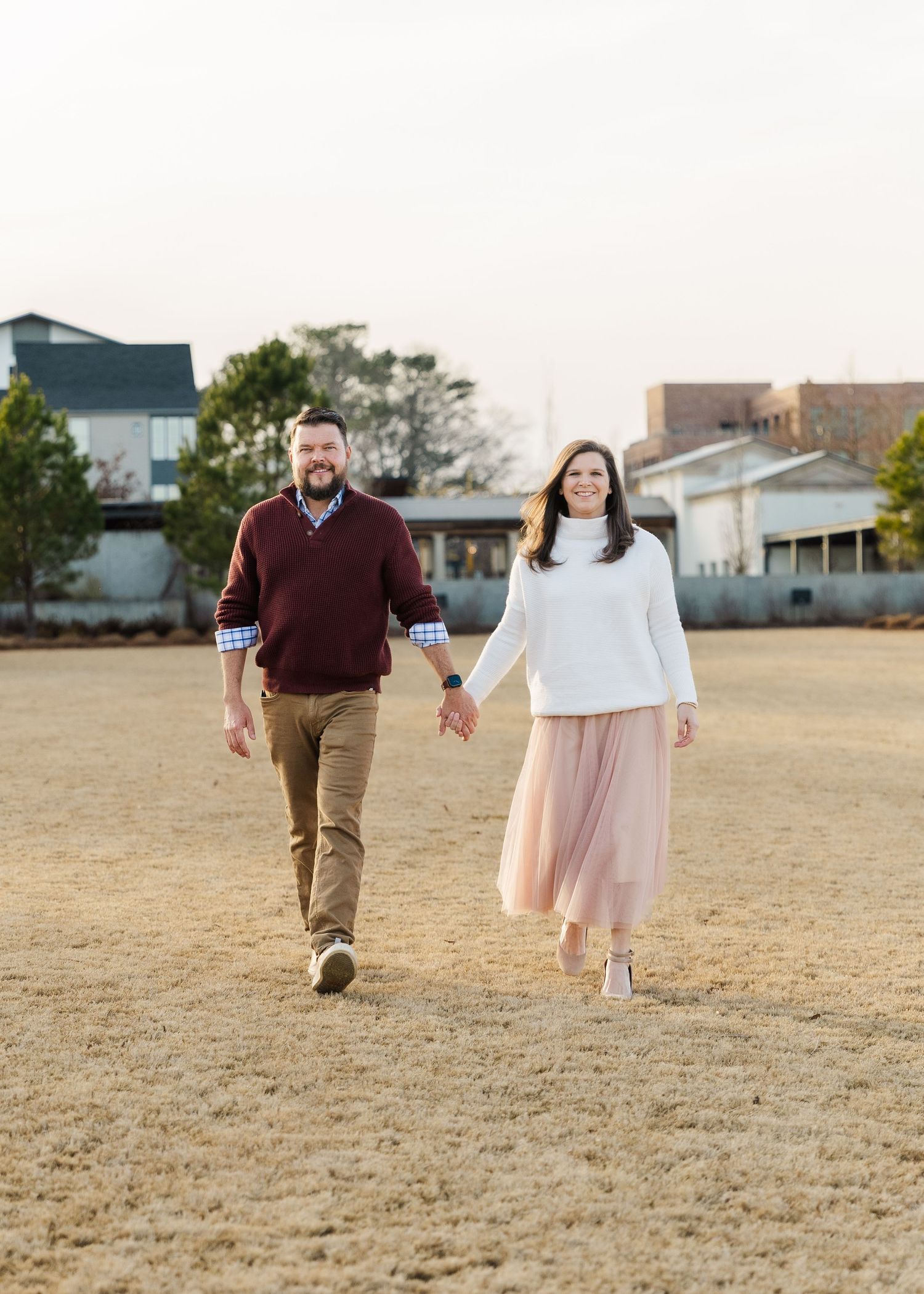 People walking together across an open field during golden hour.