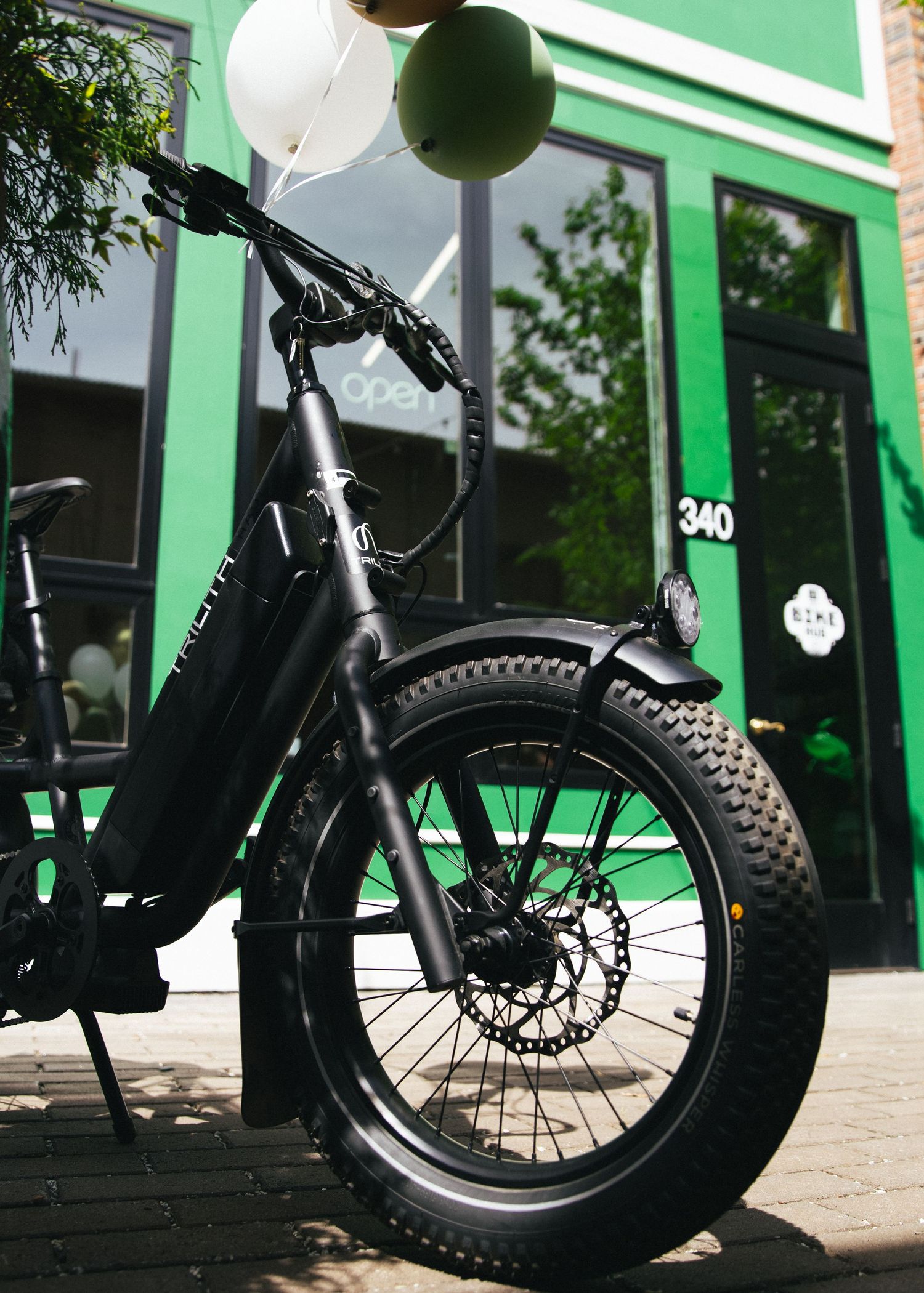 Close-up shots of a fat tire bicycle wheel and frame against a green storefront.