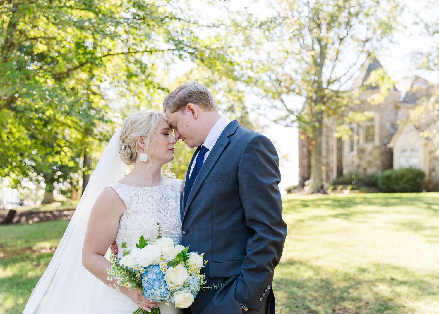 Newlyweds share tender moments in garden setting with natural sunlight.