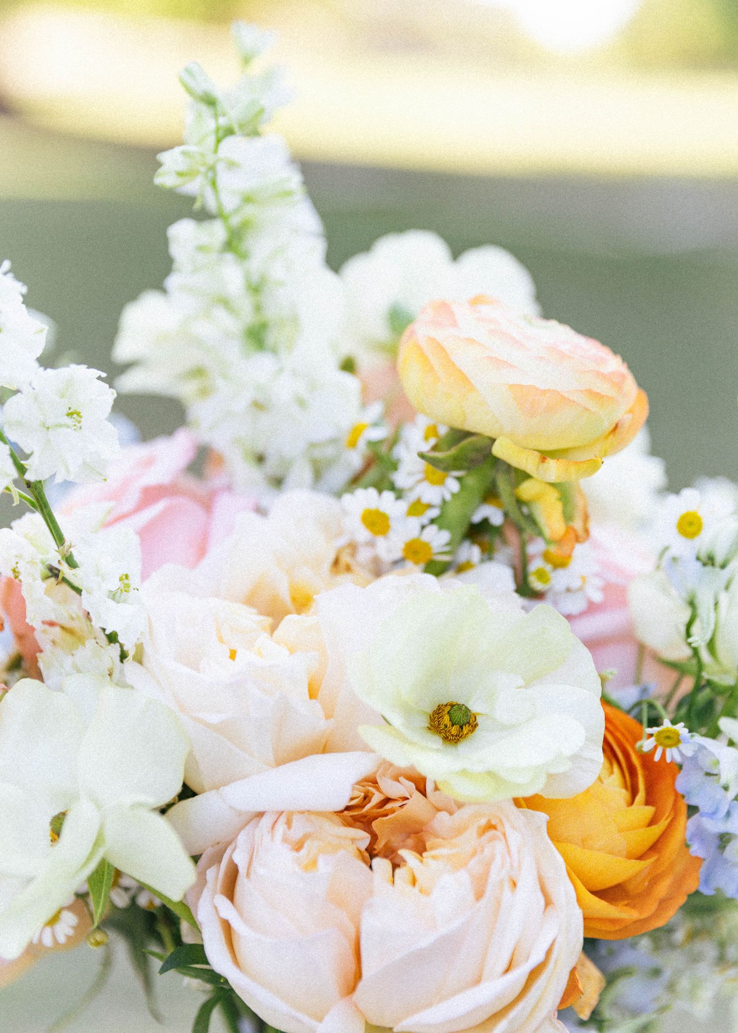 Romantic floral arrangement with peach roses, white blooms, and yellow accents.