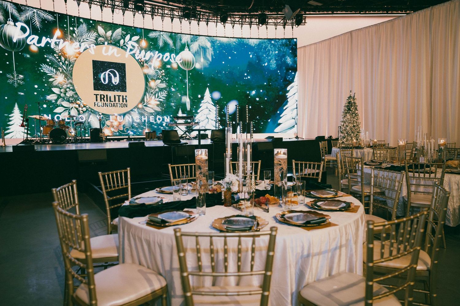 Elegant wedding reception venue with white draping and gold chiavari chairs.