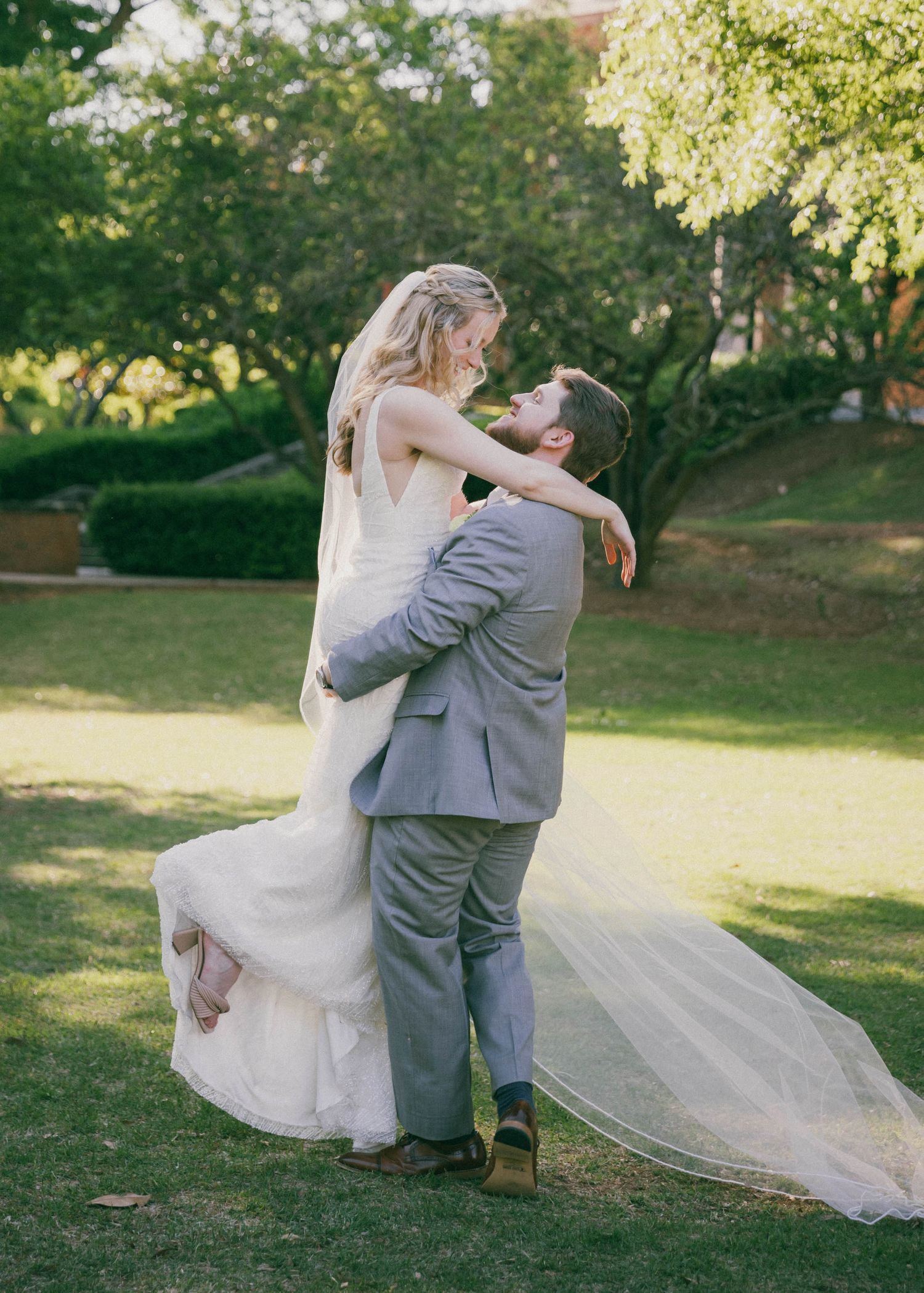 A couple dancing and twirling together on their wedding day in a garden setting.