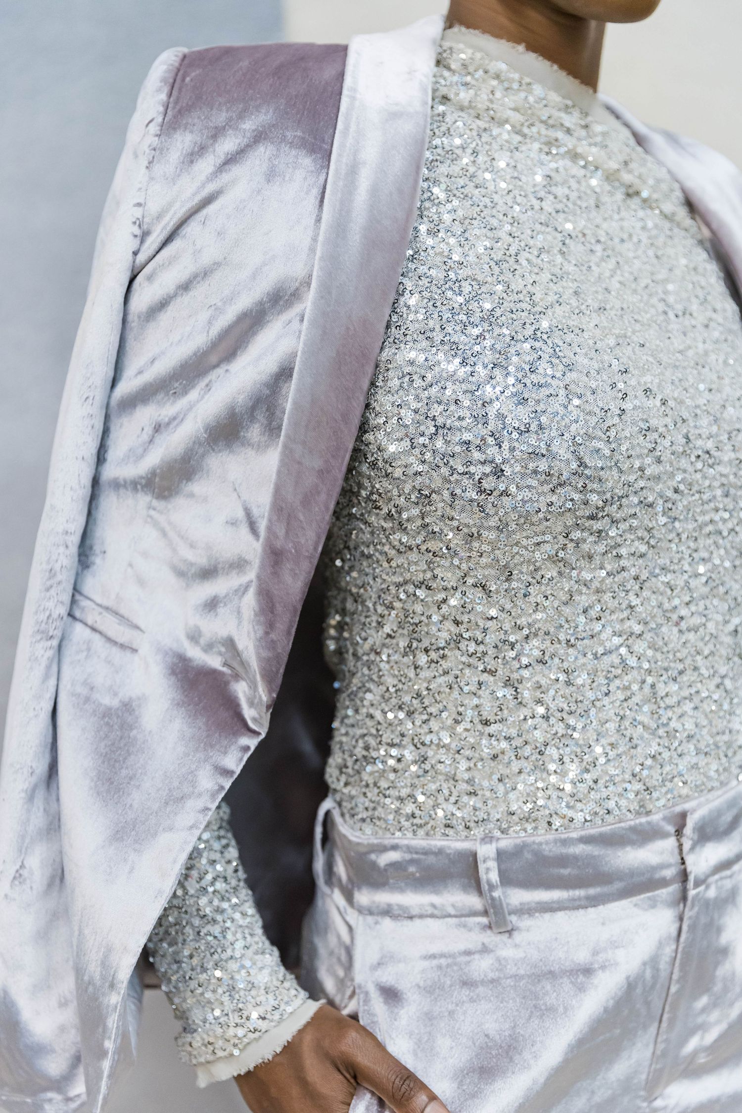 Close-up detail of silver sequined fabric on light colored clothing.