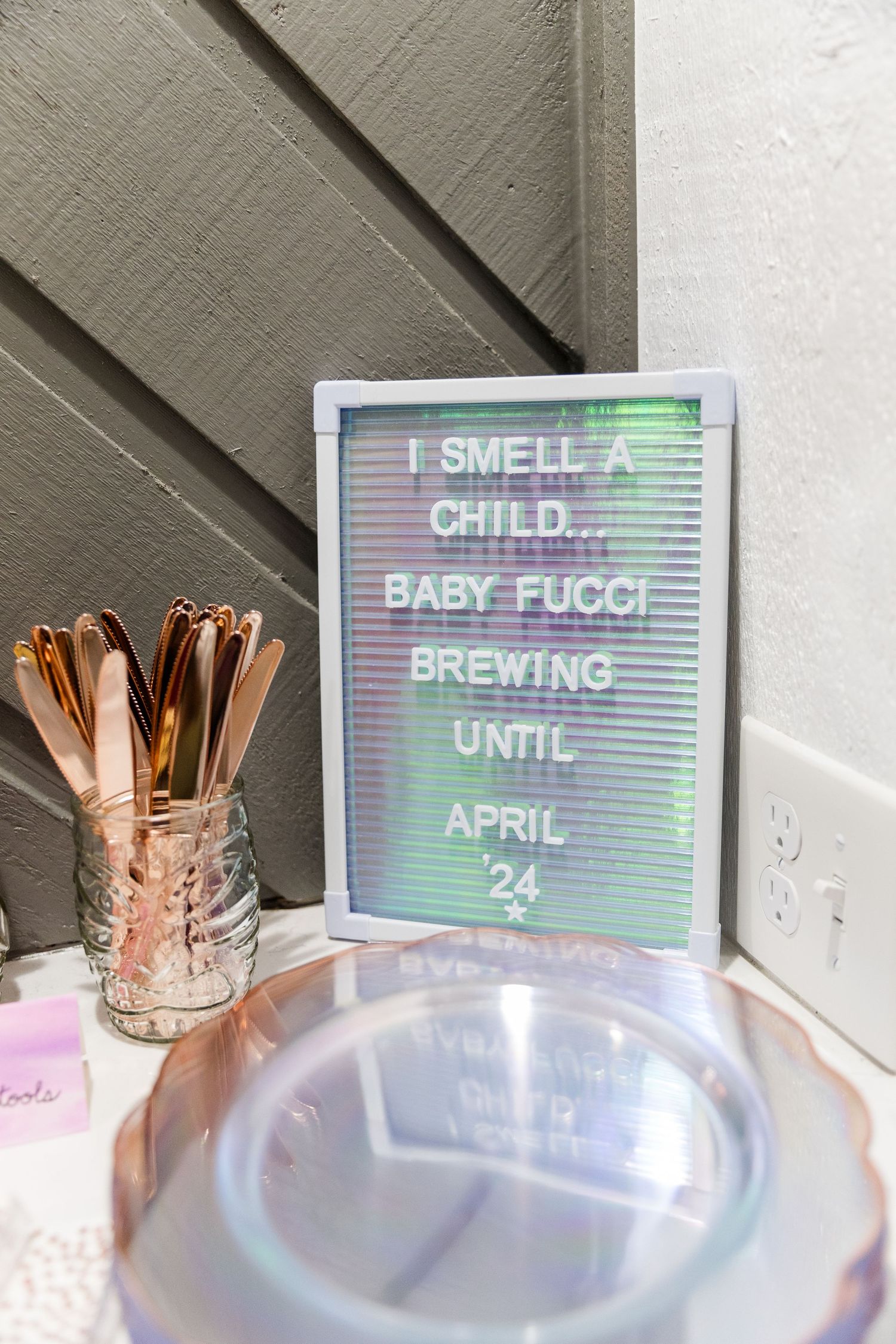 Rose gold utensils and letter board signs displayed at baby shower event.