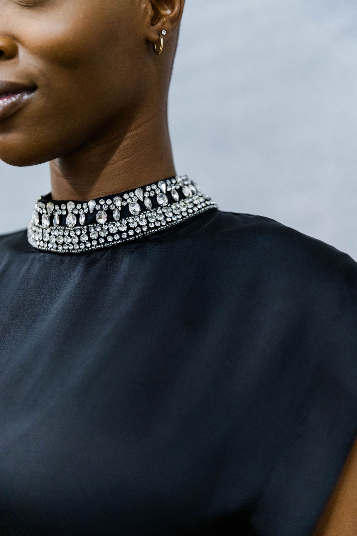 Black garment with ornate crystal-embellished neckline detail.