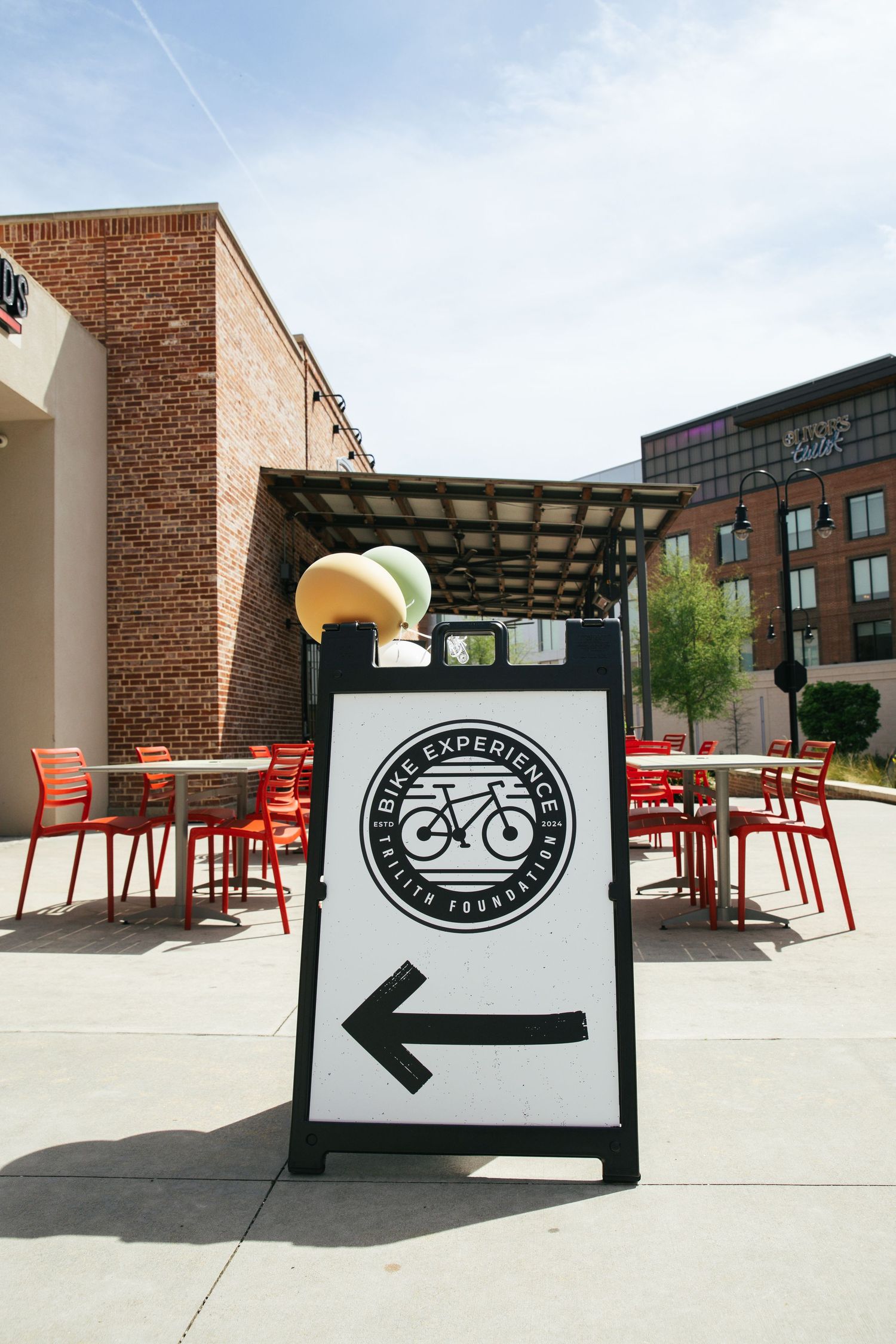 Outdoor seating area with red chairs and bike shop signage visible in multiple angles.