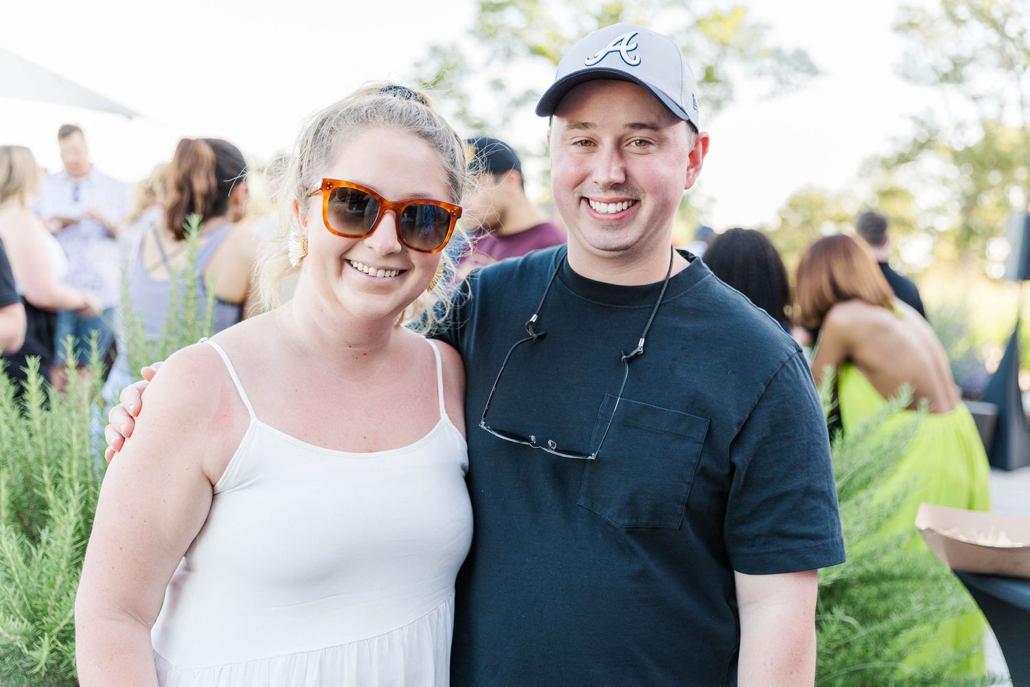 People gathered at an outdoor social event wearing casual summer attire.