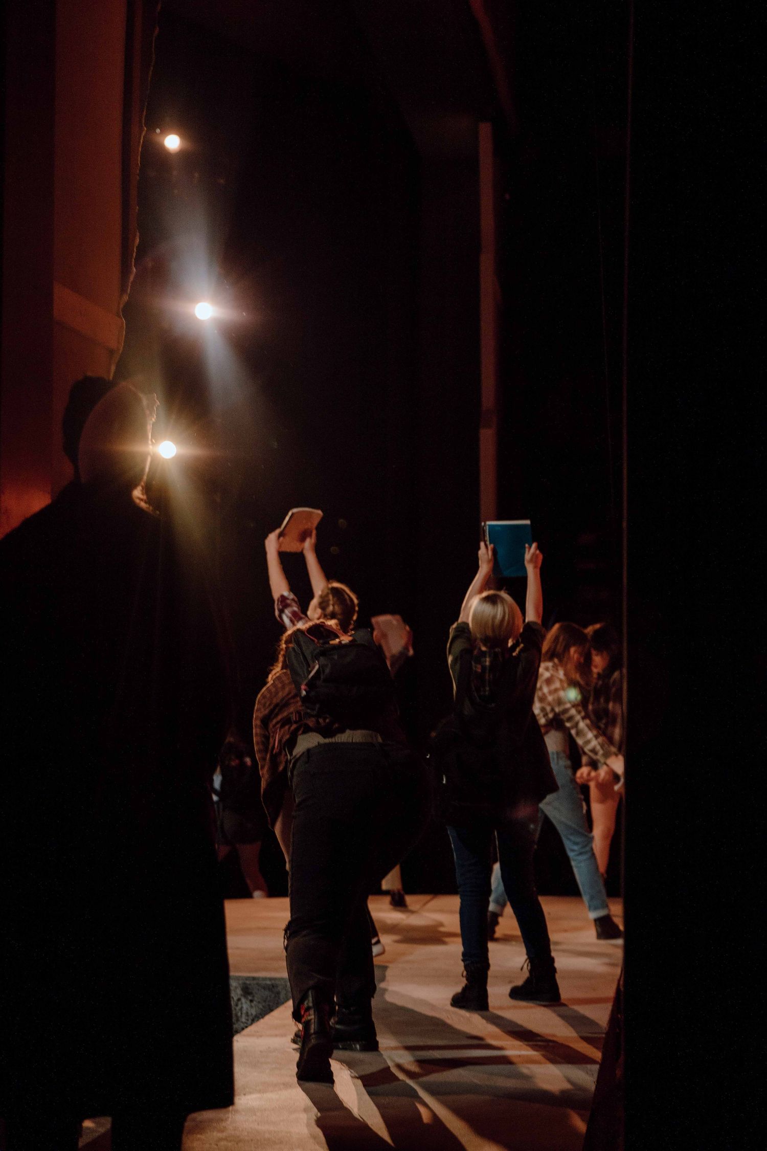 Silhouettes of people dancing in a dimly lit room with atmospheric lighting.