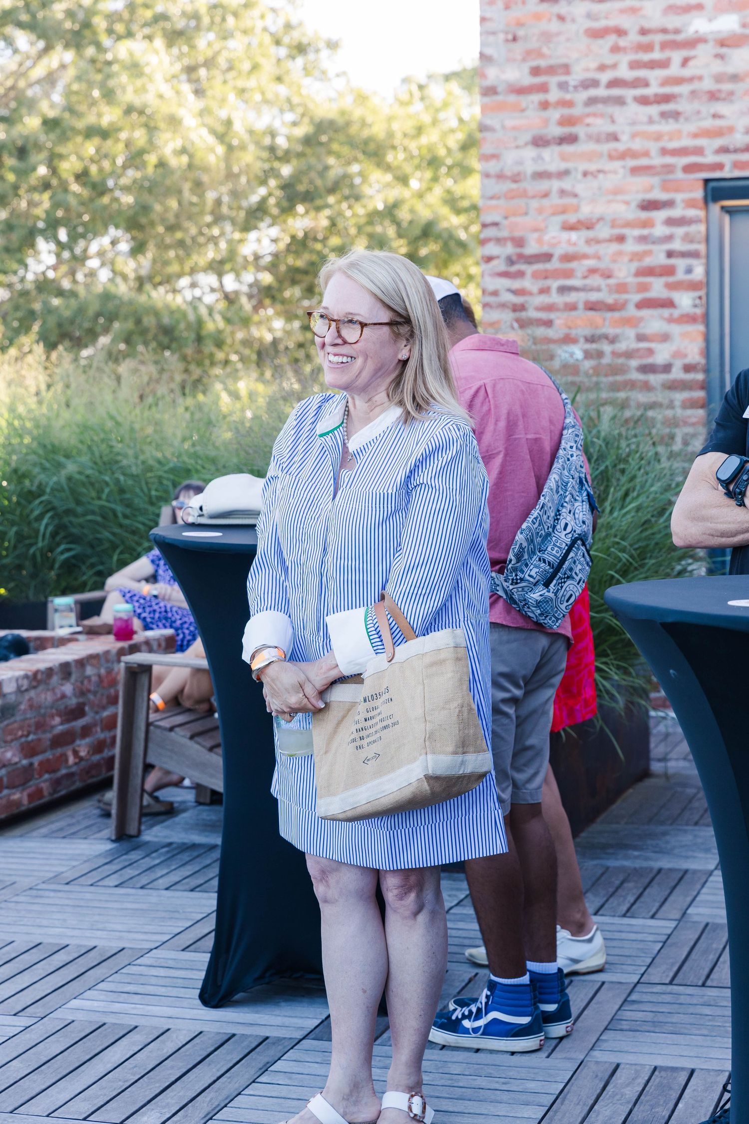 Guests mingling on a wooden deck during an outdoor social gathering.