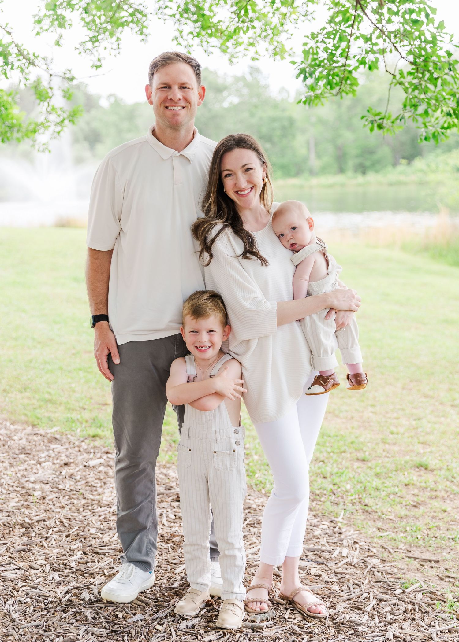 Family wearing coordinated white outfits poses together outdoors.