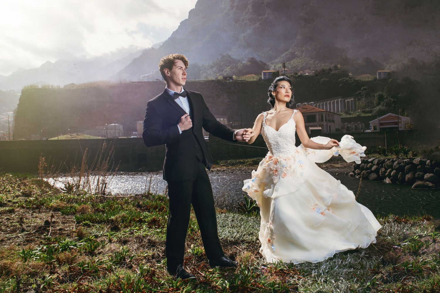 Dramatic wedding photos taken at sunset against a mountainous landscape with flowing dress movement.