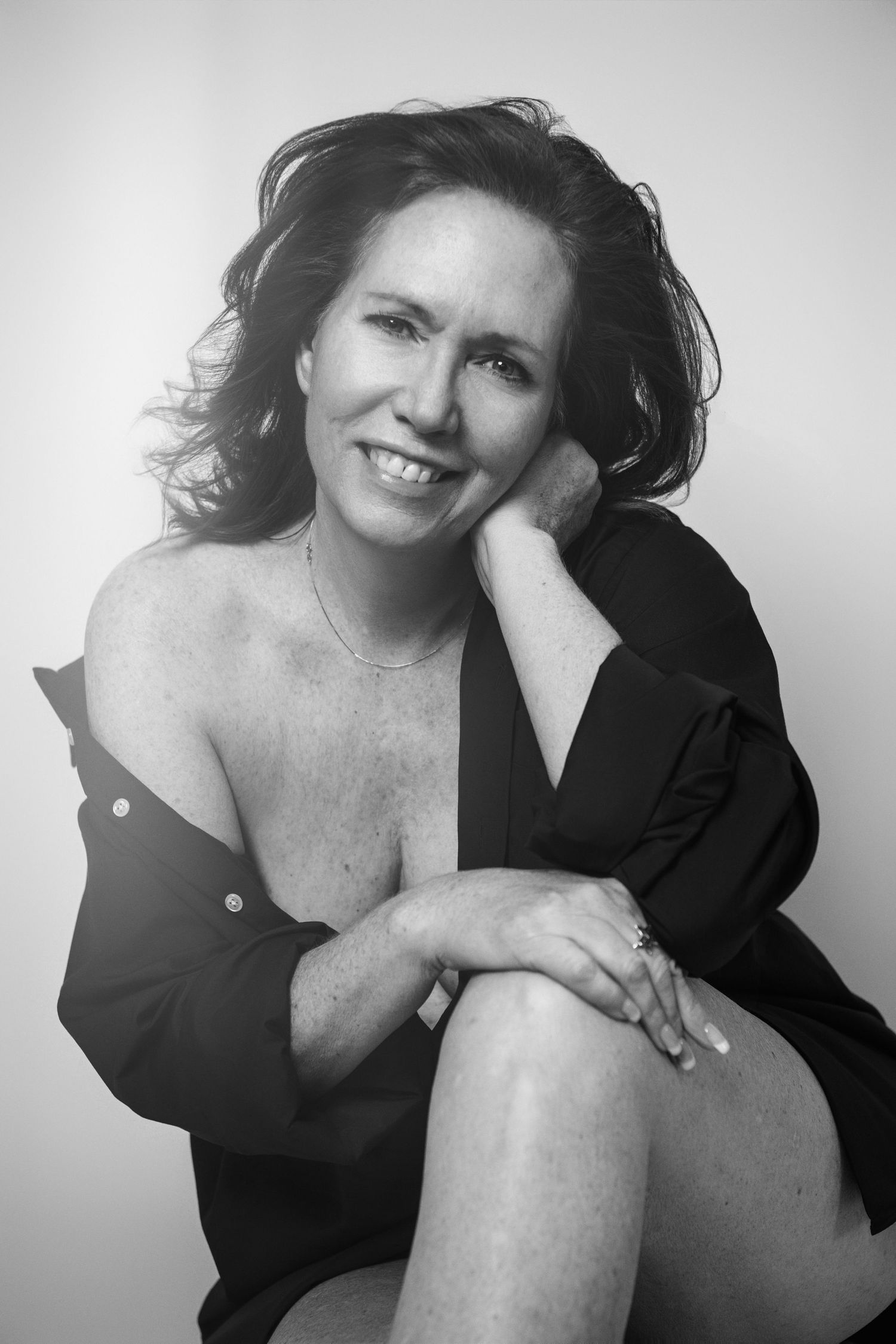 Black and white portrait series showing a person in dark clothing posing against light background.