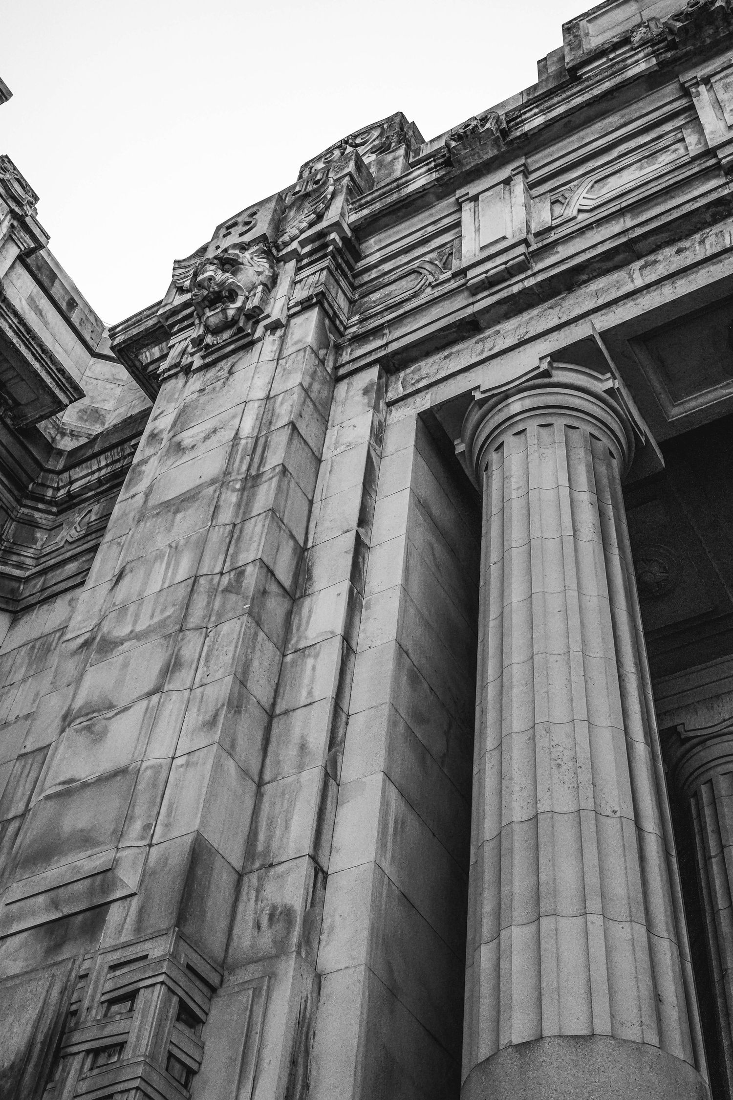 Dramatic upward view of classical architecture featuring massive stone columns and ornate details.