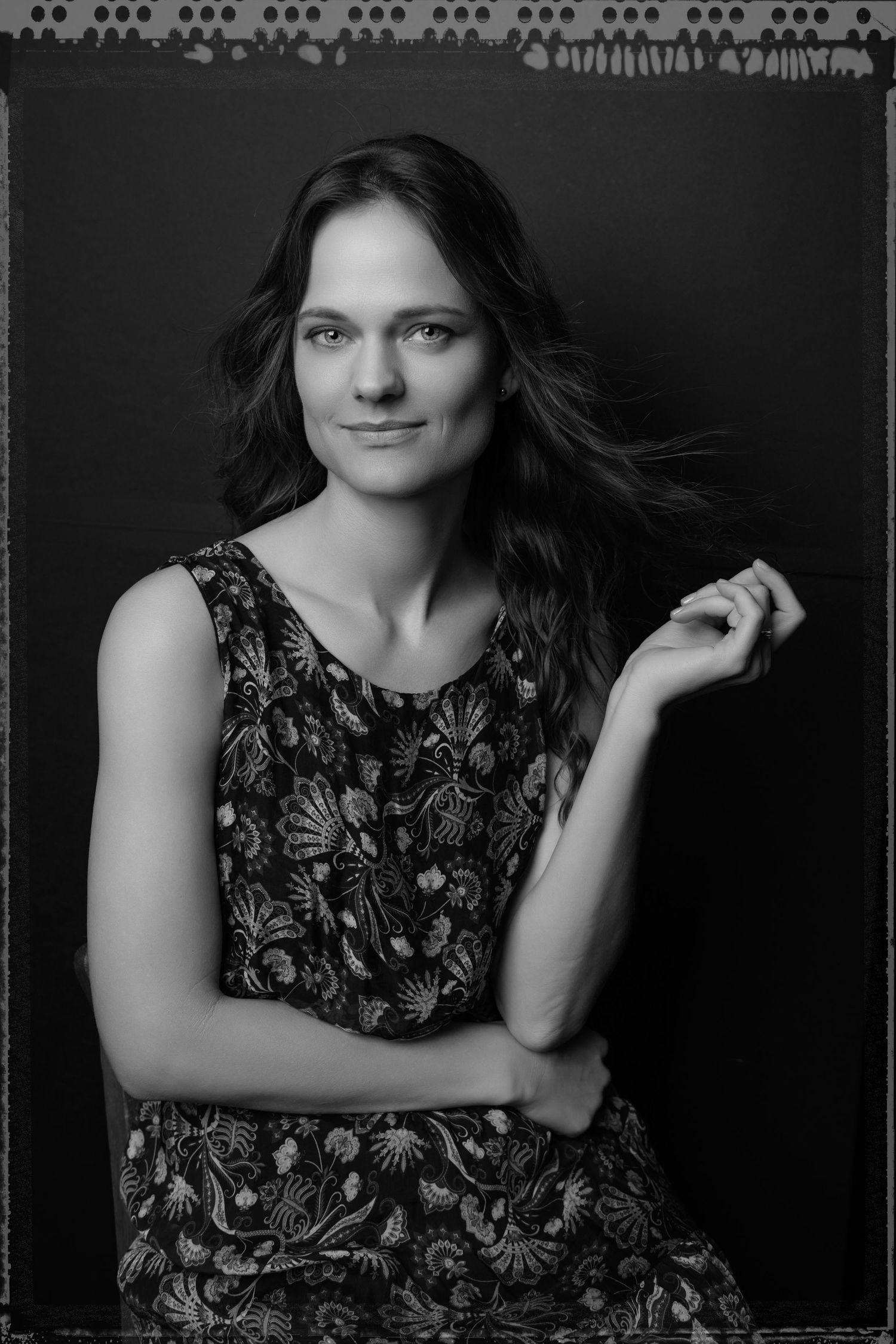 Moody black and white portraits in floral print top with dramatic lighting.