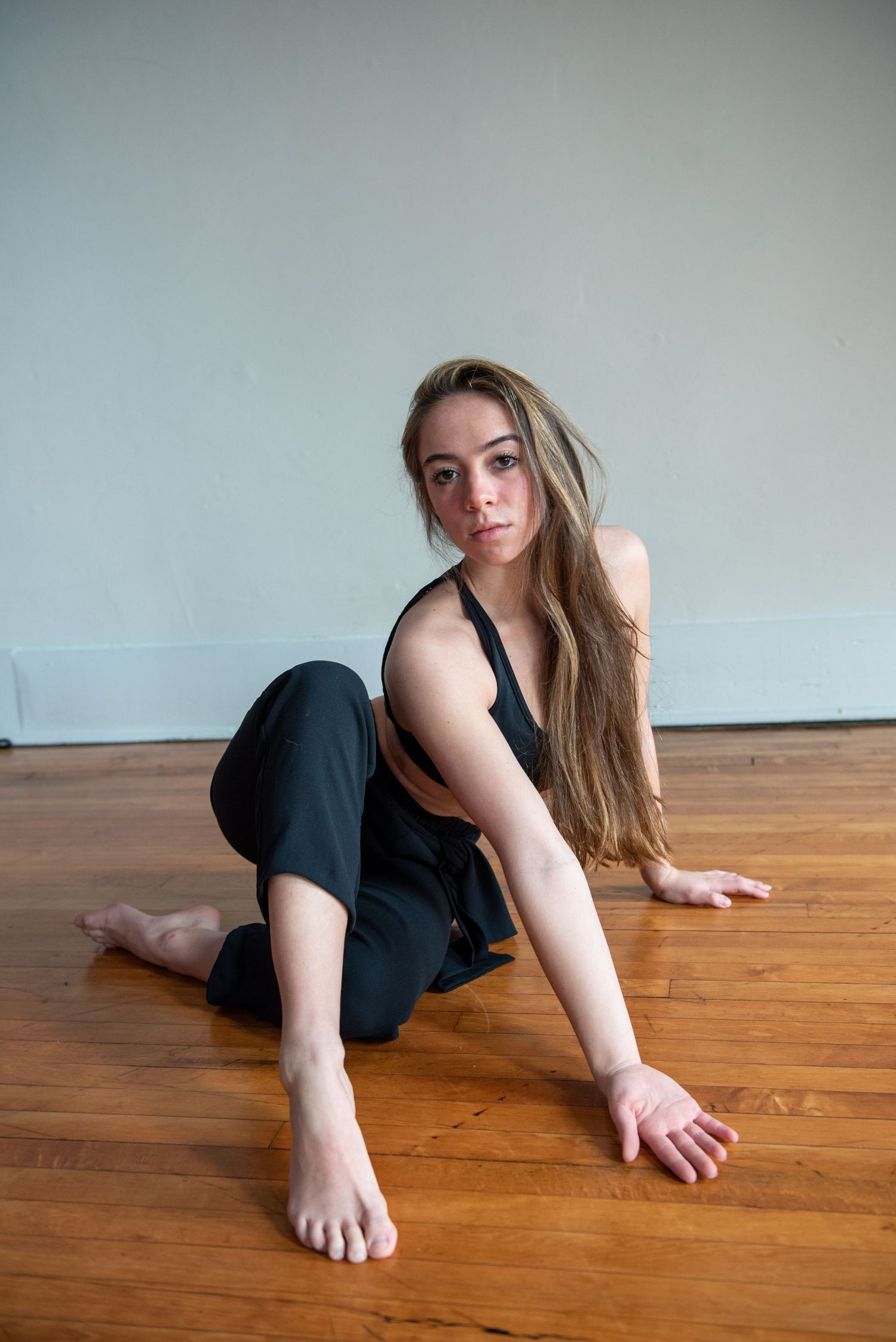 Floor work dance sequence showing graceful movements against wooden flooring.