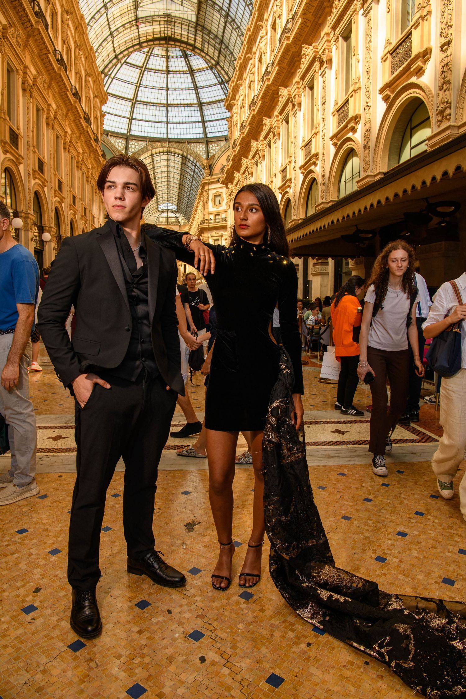 Elegant shopping gallery with ornate glass ceiling and marble floors in warm golden tones.