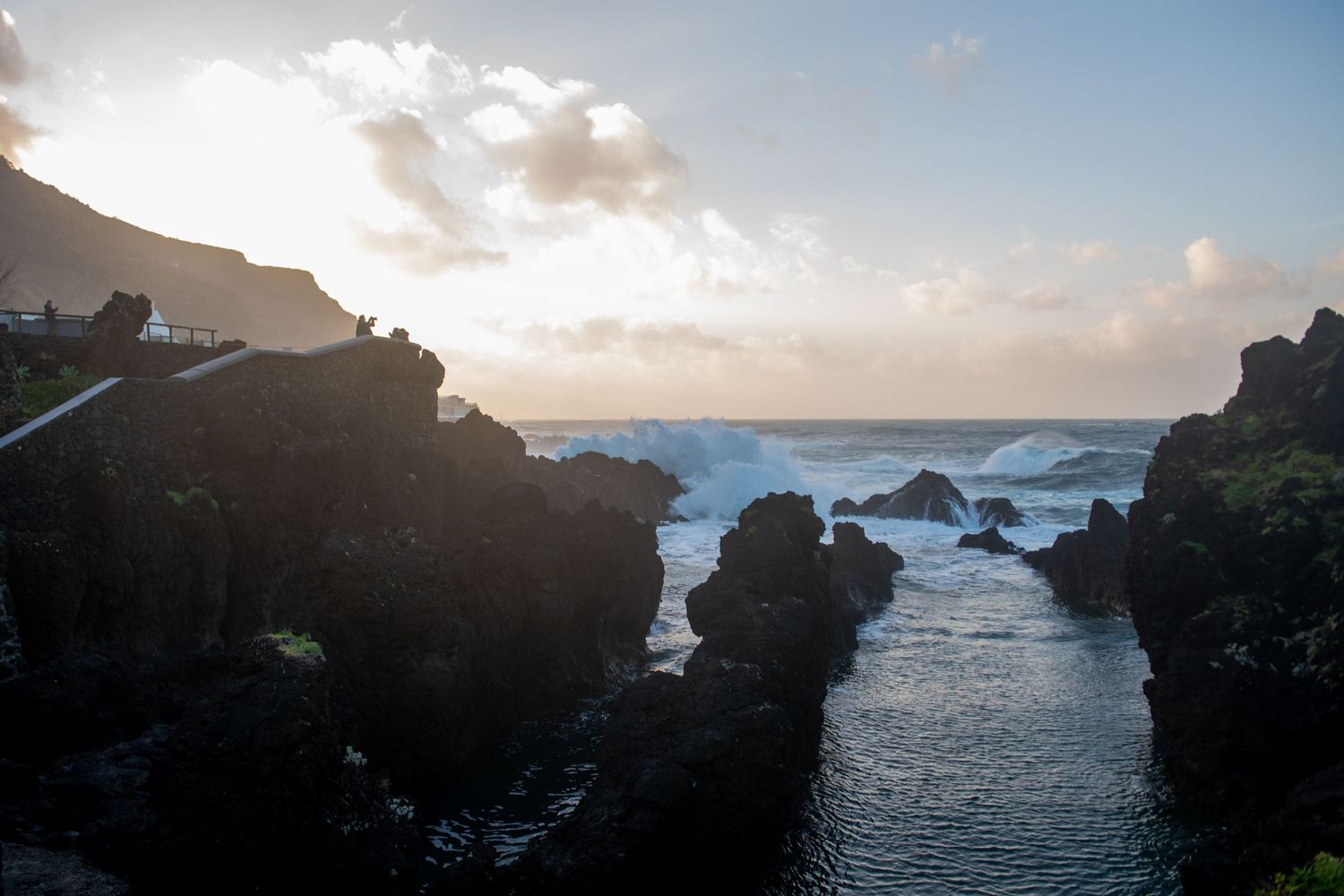 Rocky coastal formations at sunset creating natural channels into the ocean.