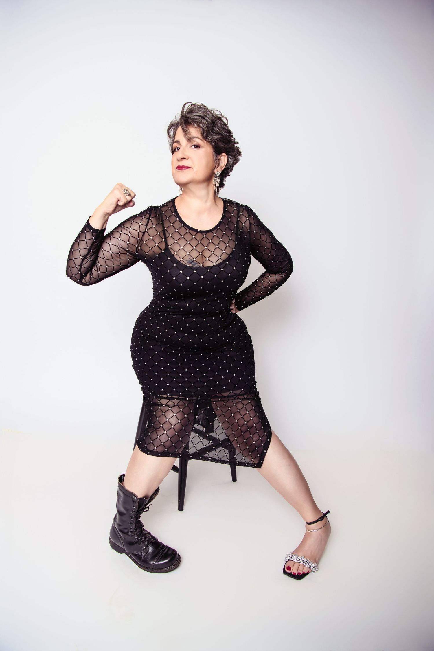 Dynamic poses in sheer polka dot dress and boots against white studio background. Celebrating female veterans and sexual assault Survivors.