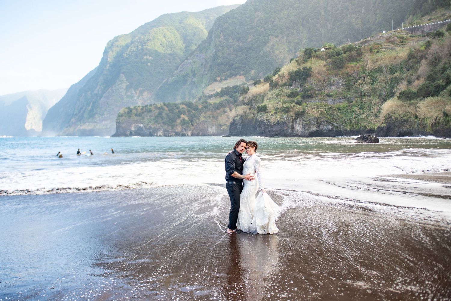 Wedding photography sequence on a dramatic black sand beach with mountain backdrop.