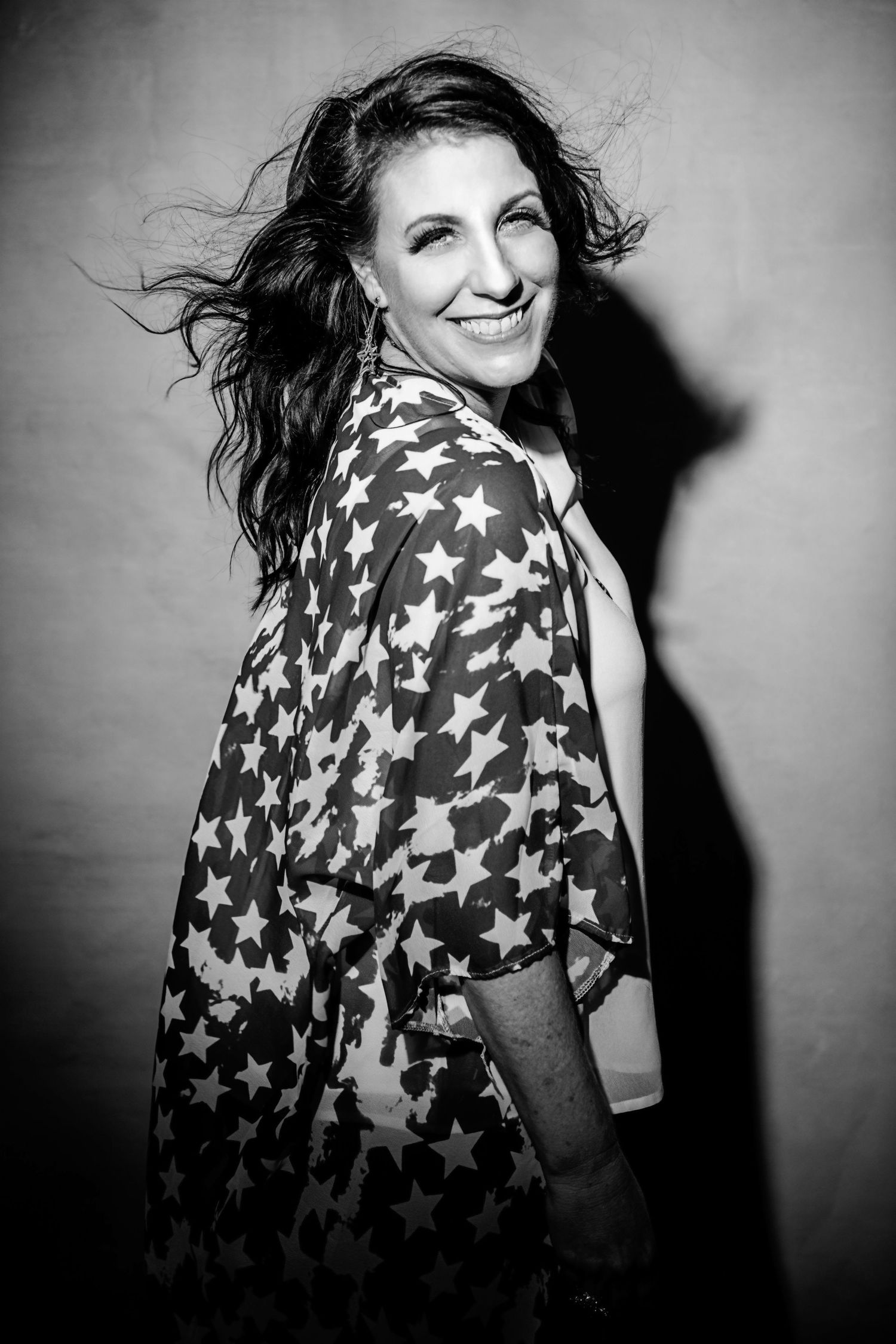 Black and white portraits wearing star-patterned top with dramatic lighting.