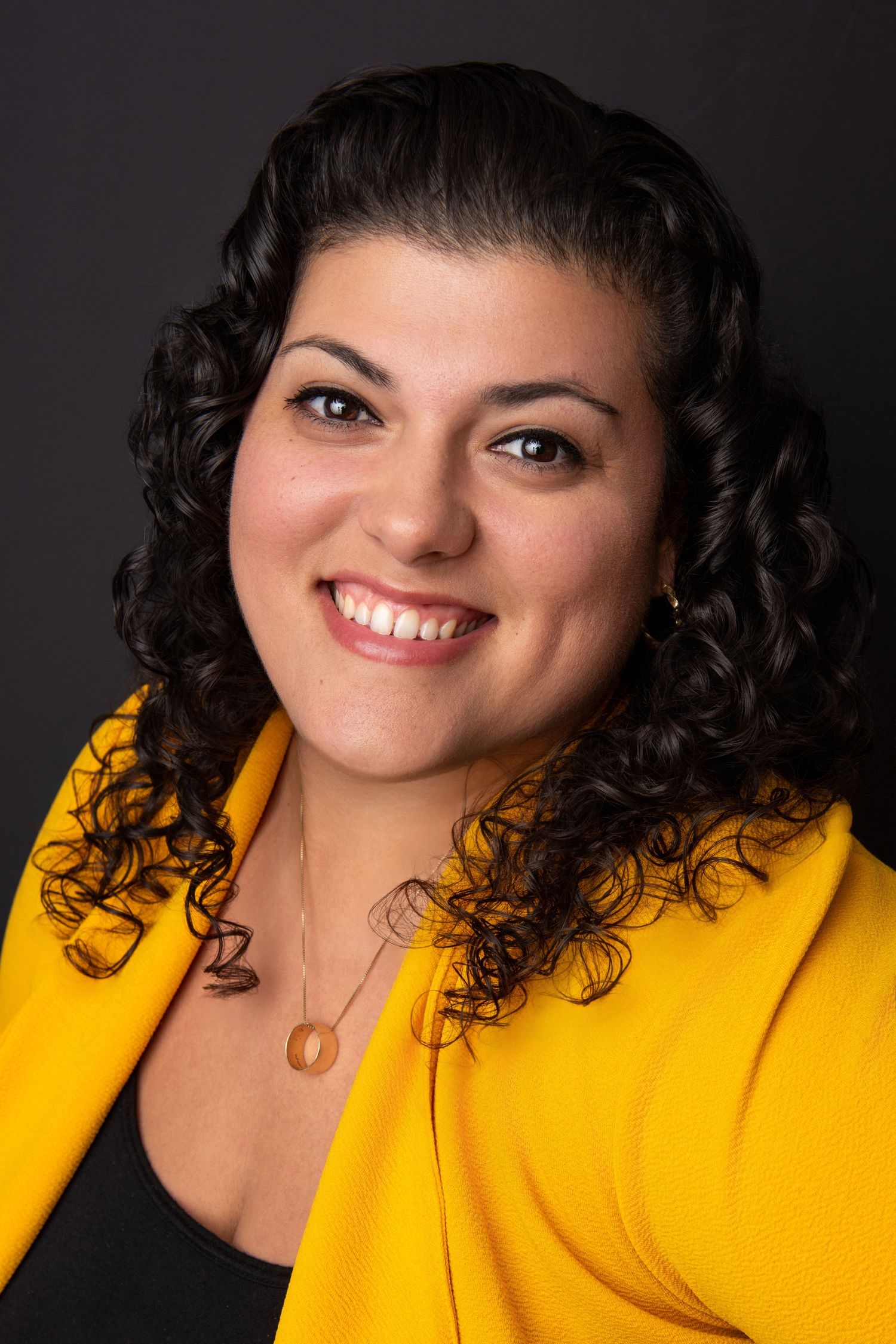 Portrait series in bright yellow blazer against dark background showing joyful expressions.