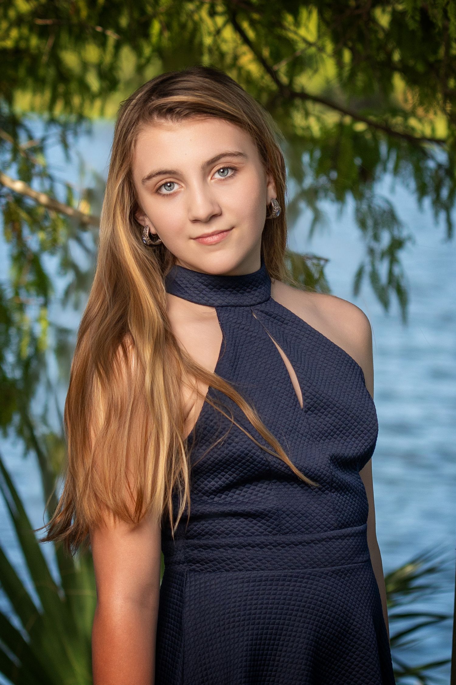 Portrait shots near water featuring a navy blue dress against natural scenery.