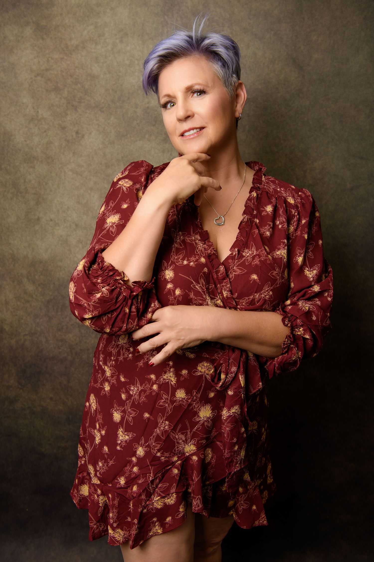 Artistic portraits in burgundy floral dress against textured brown backdrop.